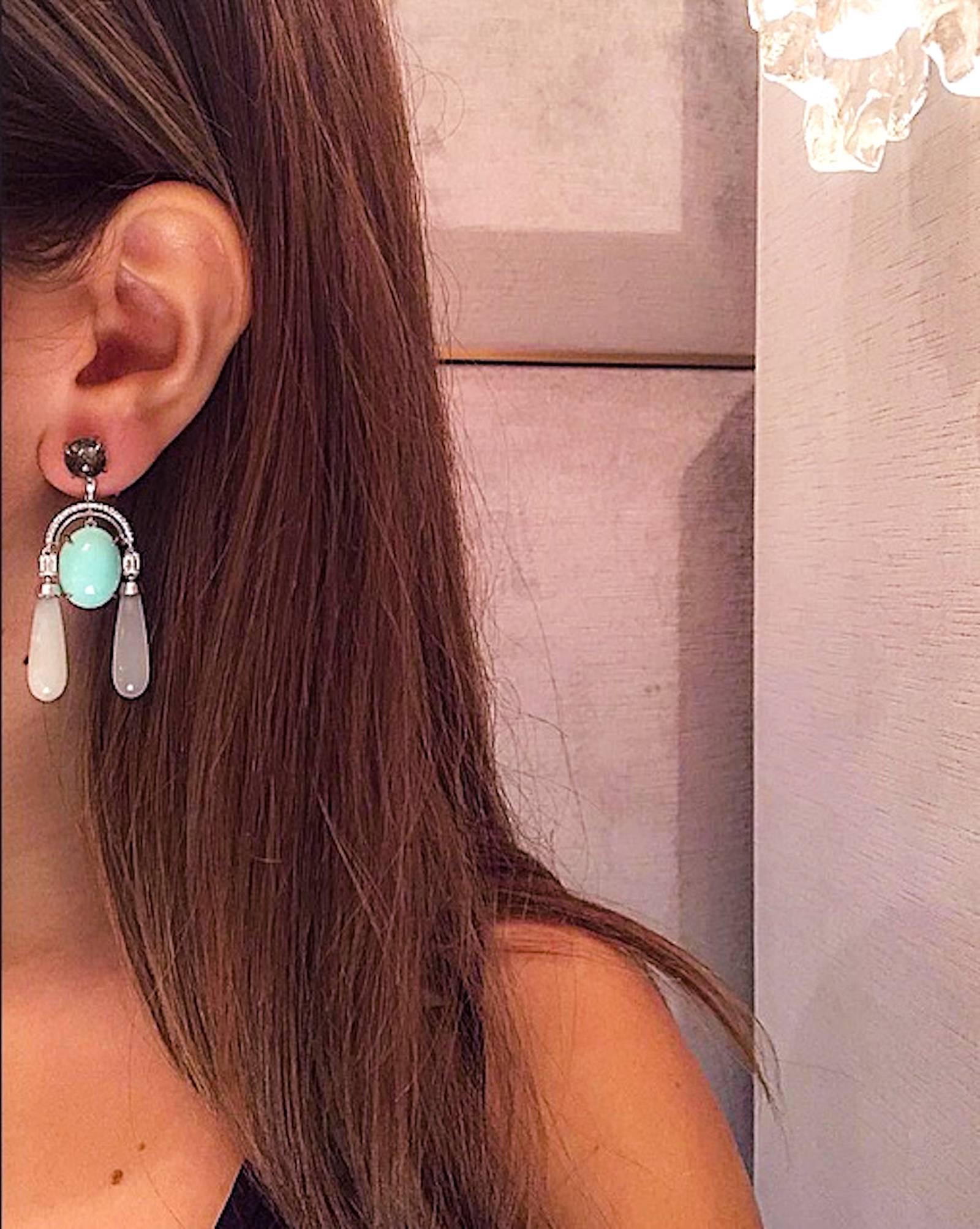 A pair of Alexandra Mor Diamond Arch earrings featuring four Emerald-cut Diamonds totaling 0.82 carats with color and clarity F VS, and forty-six Diamonds totaling 0.25 carats accented with Green Cabochon Opals, Moonstones and Black Rutilated