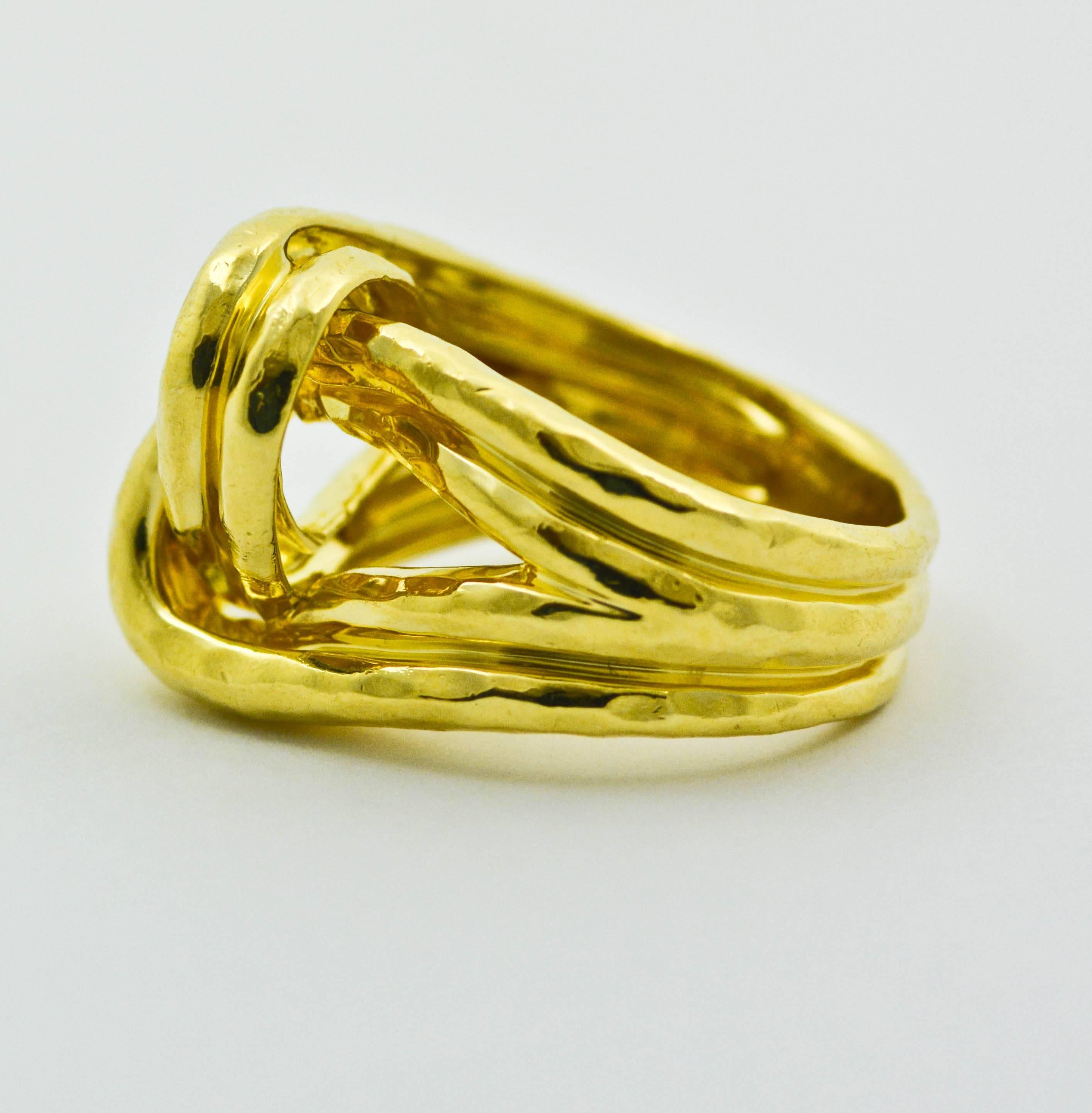 This ring is a classic Henry Dunay design. Fashioned from 18kt yellow gold, it features artistic, intertwining gold ribbons that loop through and twist around each other. The surface is highly polished and is finished with a classic Henry Dunay