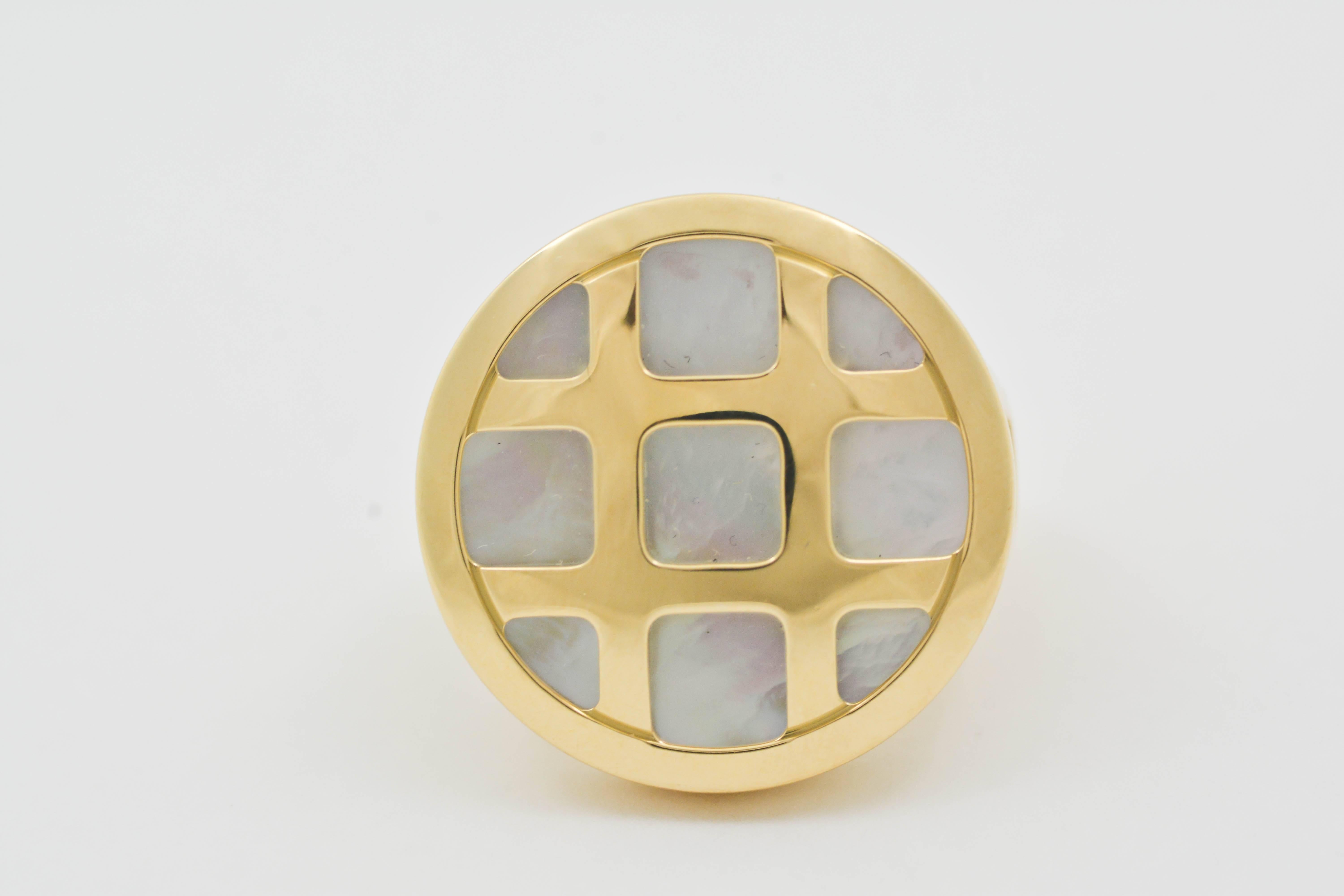 Classic 18kt yellow gold is expertly crafted in this Cartier design. The “Pasha” ring is set with a beautiful, white, mother-of-pearl background, and the yellow gold forms a tic-tac-toe pattern at the top. Measuring 24.27mm in diameter, this ring’s