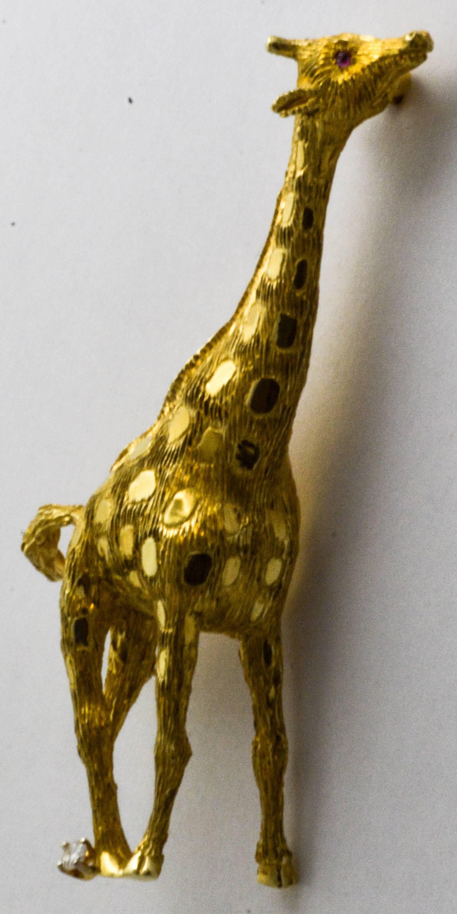 This brooch is a stunning Pampillonia design fashioned in beautiful 18 karat yellow gold in the shape of a giraffe. The surface is hand engraved to capture the texture of hair. Measuring 65.5 mm tall and 27 mm wide, the pin is set with a pair of