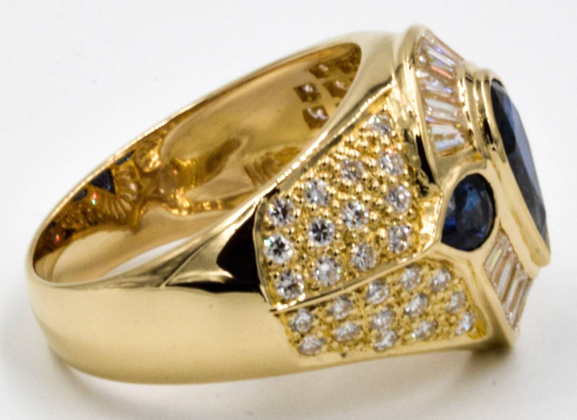 This classy, 18 karat yellow gold ring features a 1.5 carat, pear-shaped sapphire with an intense, vibrant blue color. Two smaller blue sapphires (combined weight of 0.44 carats) create a lovely accent. Framing the sapphires is a channel set halo of