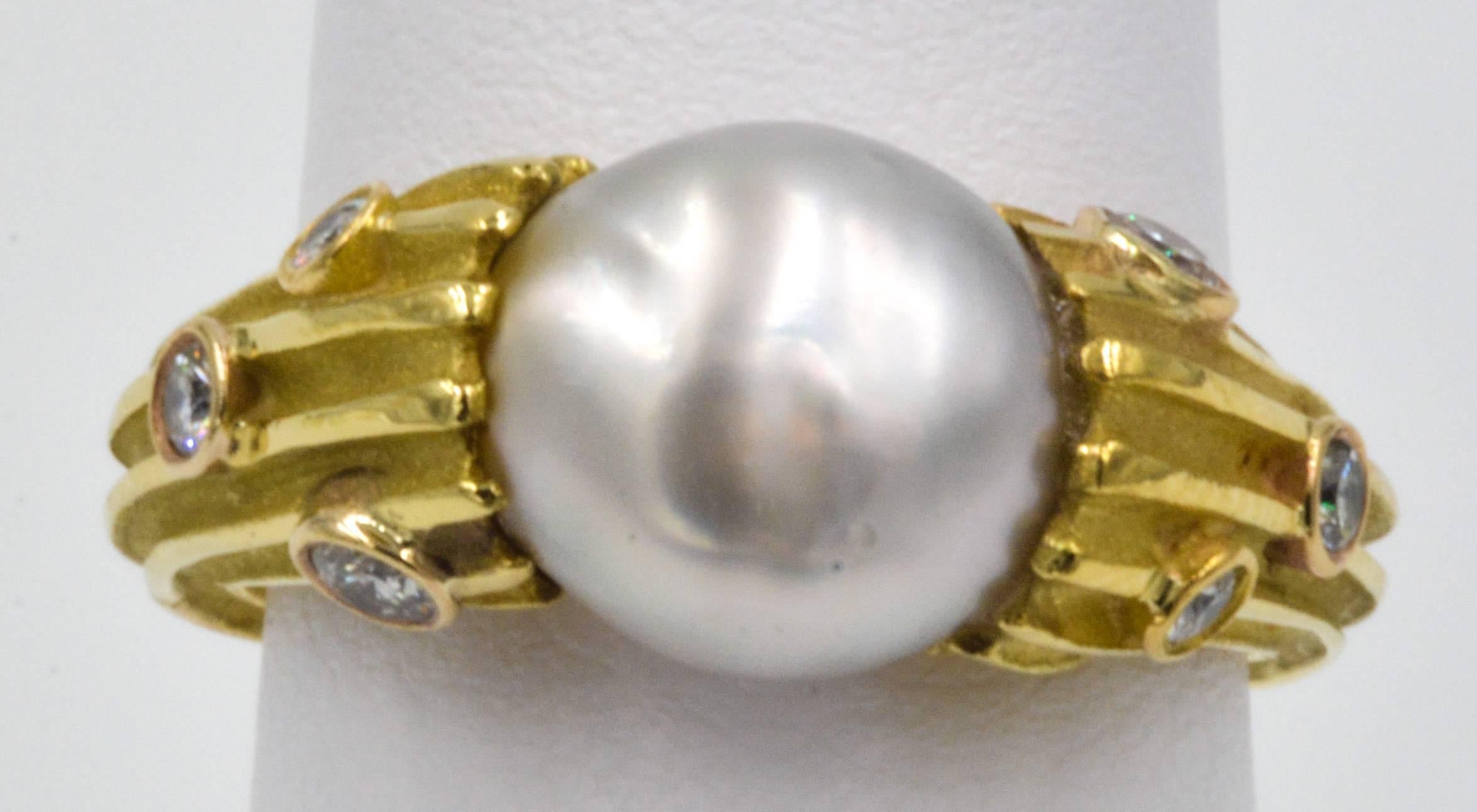 This classic 18kt yellow gold Christopher Walling ring is centered with a baroque pearl that measure 8-9 mm in diameter and is designed with multiple grooves cut in the shank that are high polished on the high spots and satin finished inside the