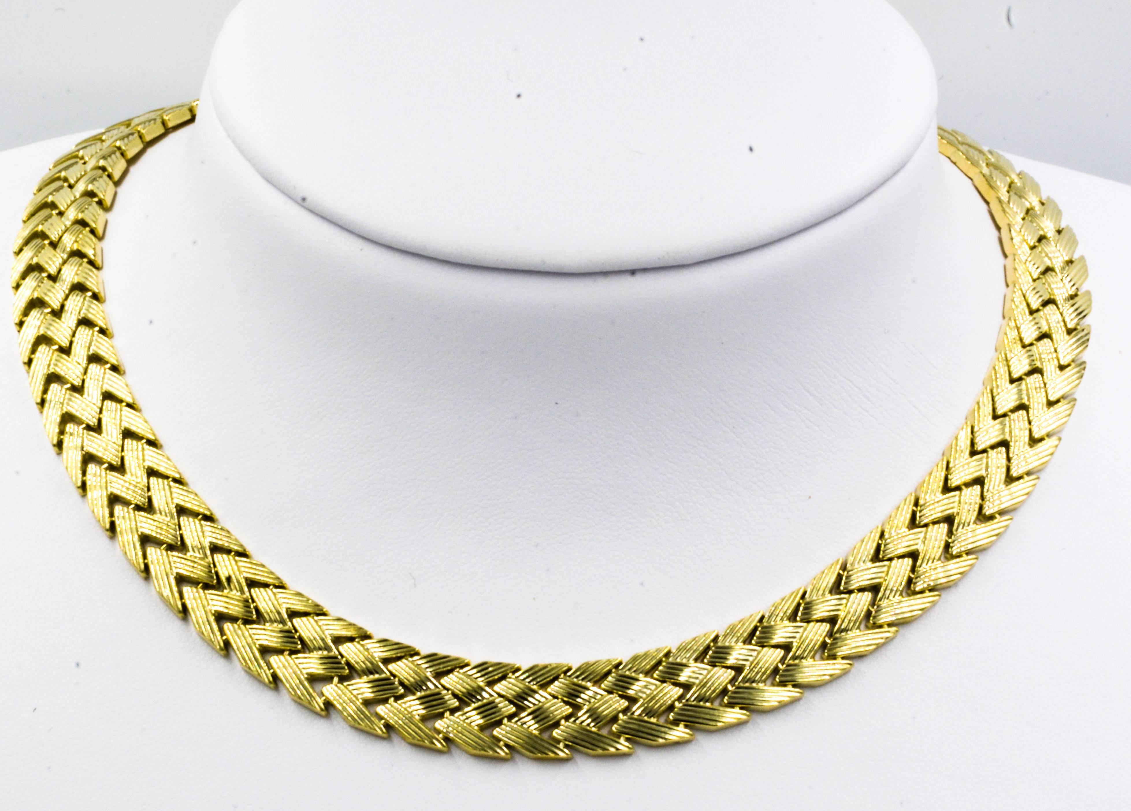 This classic 1970's style bold gold necklace features an attractive zig-zag basket weave pattern. The necklace is supple and comfortable, measuring in at 17 inches long and 1/2 inch wide.
