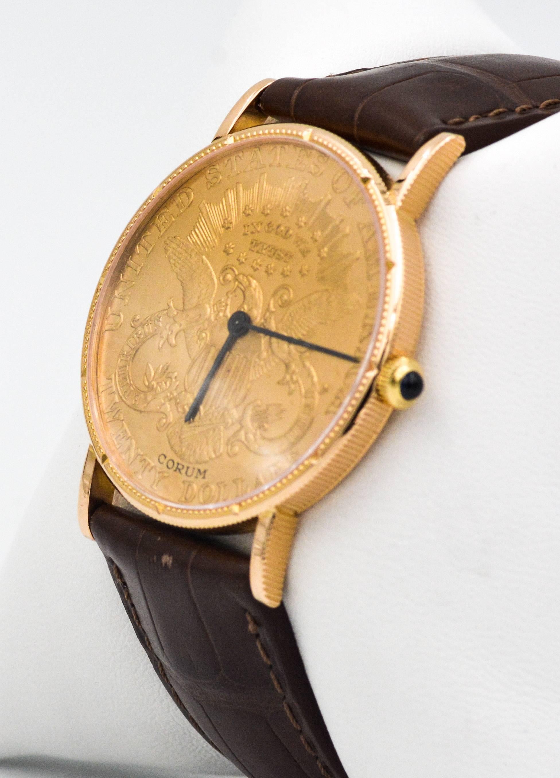 This certified pre-owned Corum watch has a Liberty $20 1904 coin dial, 35 mm 18kt yellow gold case, manual wind movement, sapphire crystal, and a brown alligator strap with 18kt yellow gold buckle.