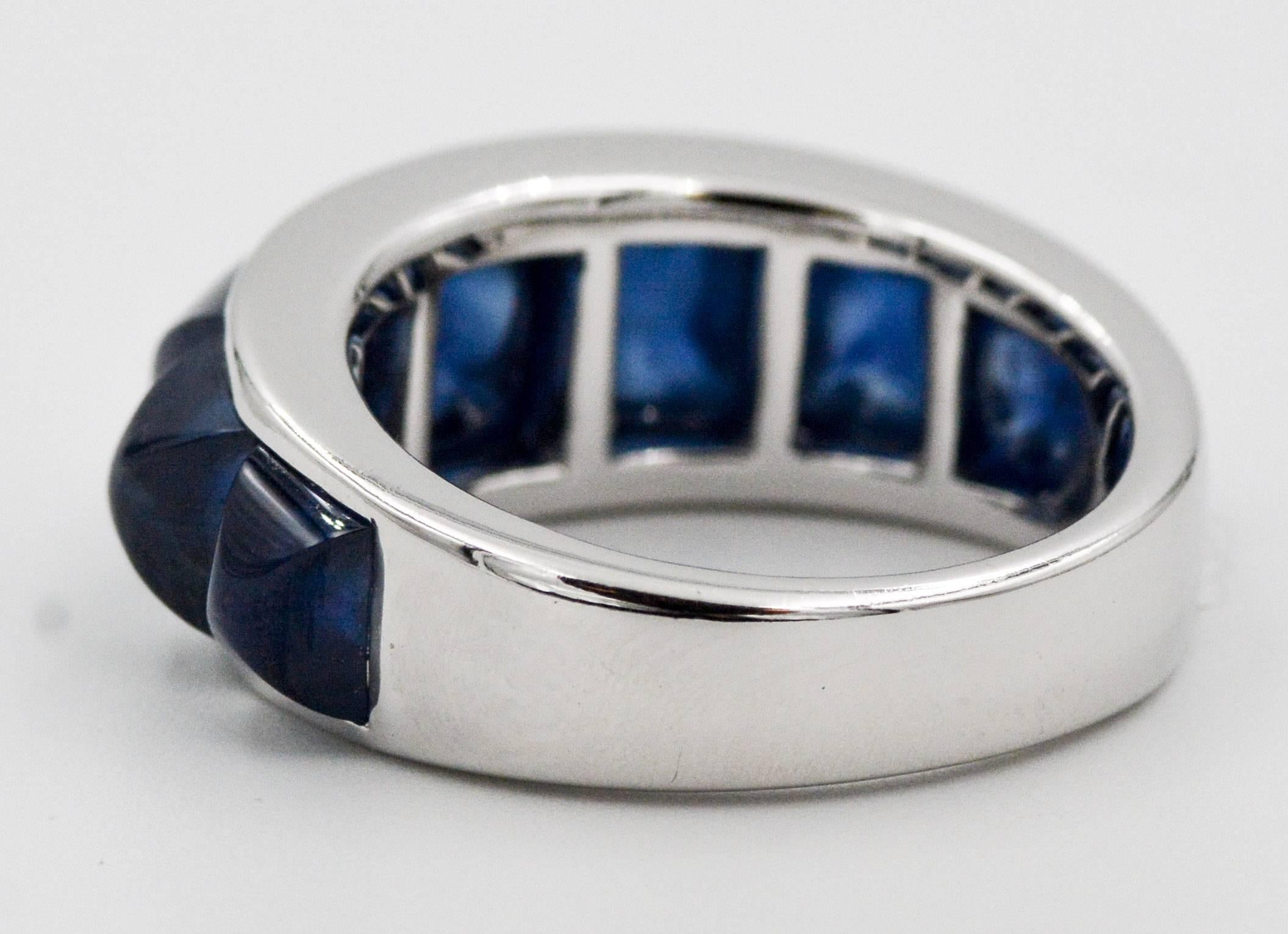 This Seaman Schepps Portofino ring is crafted of 18kt white with a channel of seven beautiful sugar loaf cut blue sapphire gems. The Sapphired gems have combined weight of 8.68 carats. The Portofino ring is stamped Seaman Schepps 243401.  The ring