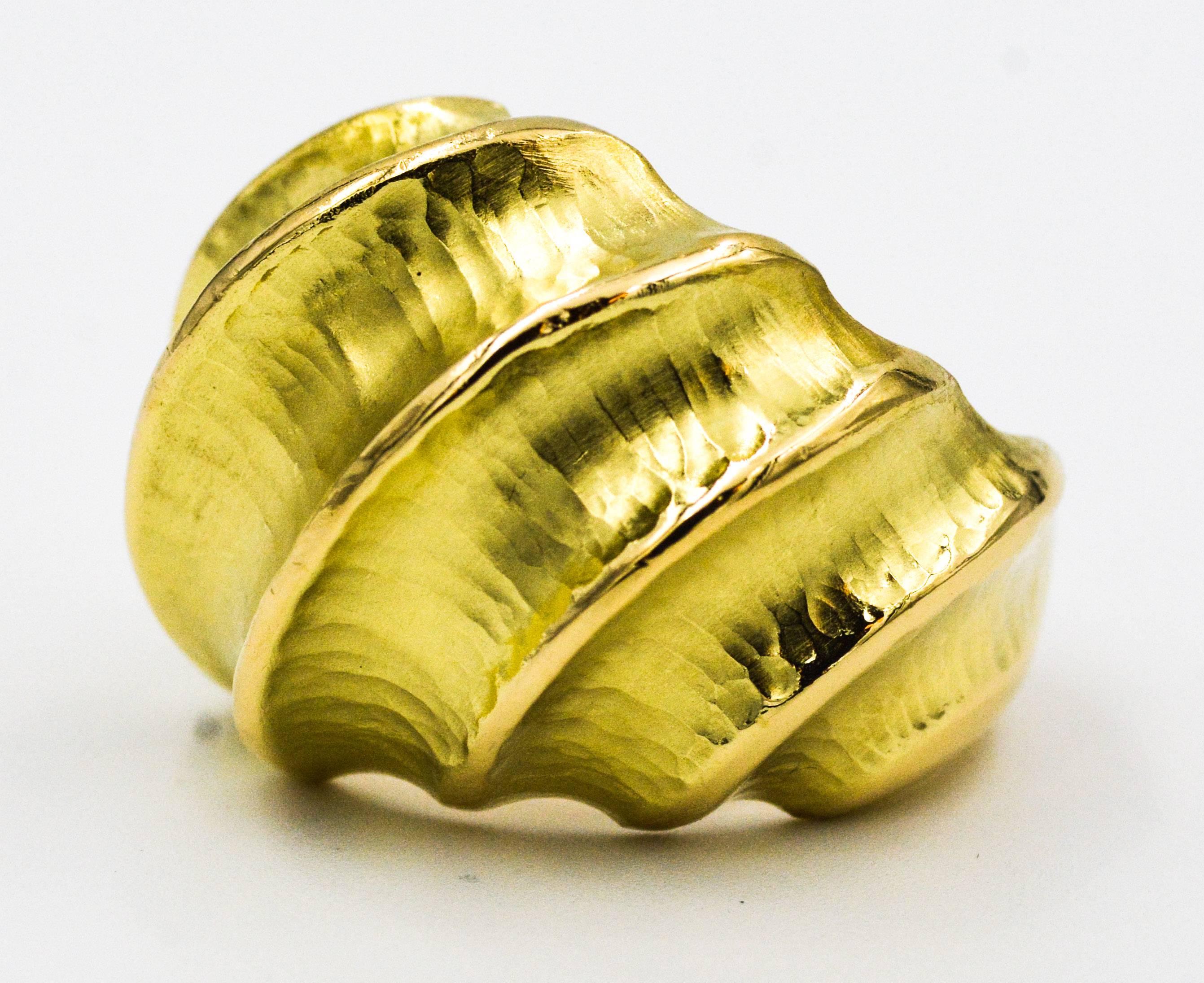 Bold and beautiful, this glamorous 18kt yellow gold ring is artistically crafted with concave hammered valleys contrasted with high polished ridges.  This 18kt yellow gold hammered finish ring is 20.75 mm wide and 9 mm deep at the top of the ring,