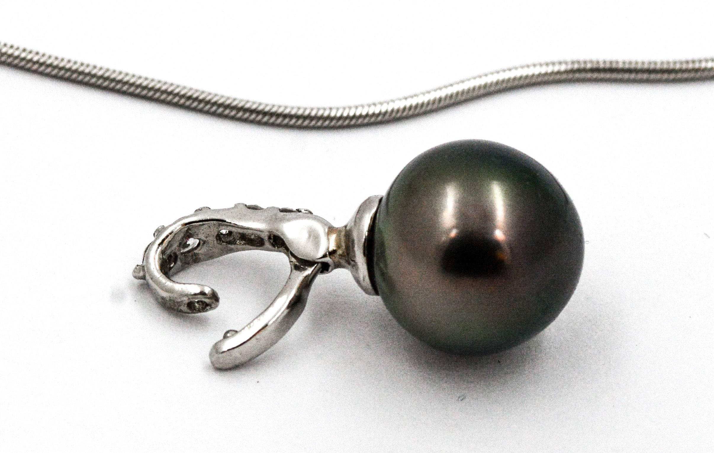 Show off your modern charm wearing this classic 10.24 mm cultured black pearl necklace. The cultured black pearl pendant is crafted in 18kt white gold with five round brilliant cut diamonds bead set in a tapered bail.  The diamonds have an