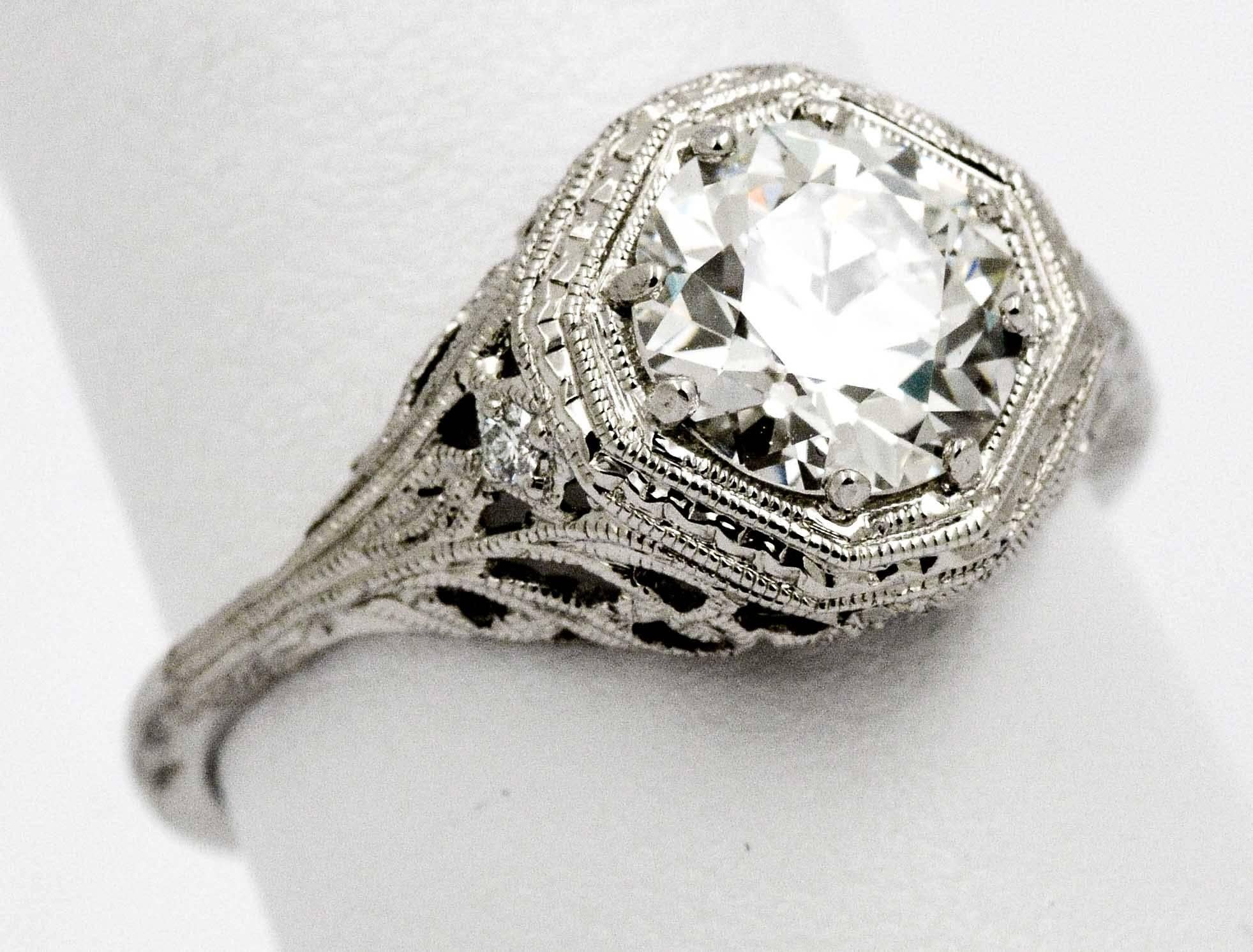 It's as if you have gone back in time with this classic Art Deco engagement ring. With flaring style this 1.52 carats round European cut diamond, with G color and VS2 clarity, is sure to catch many an eye.  The diamond is expertly set in the center