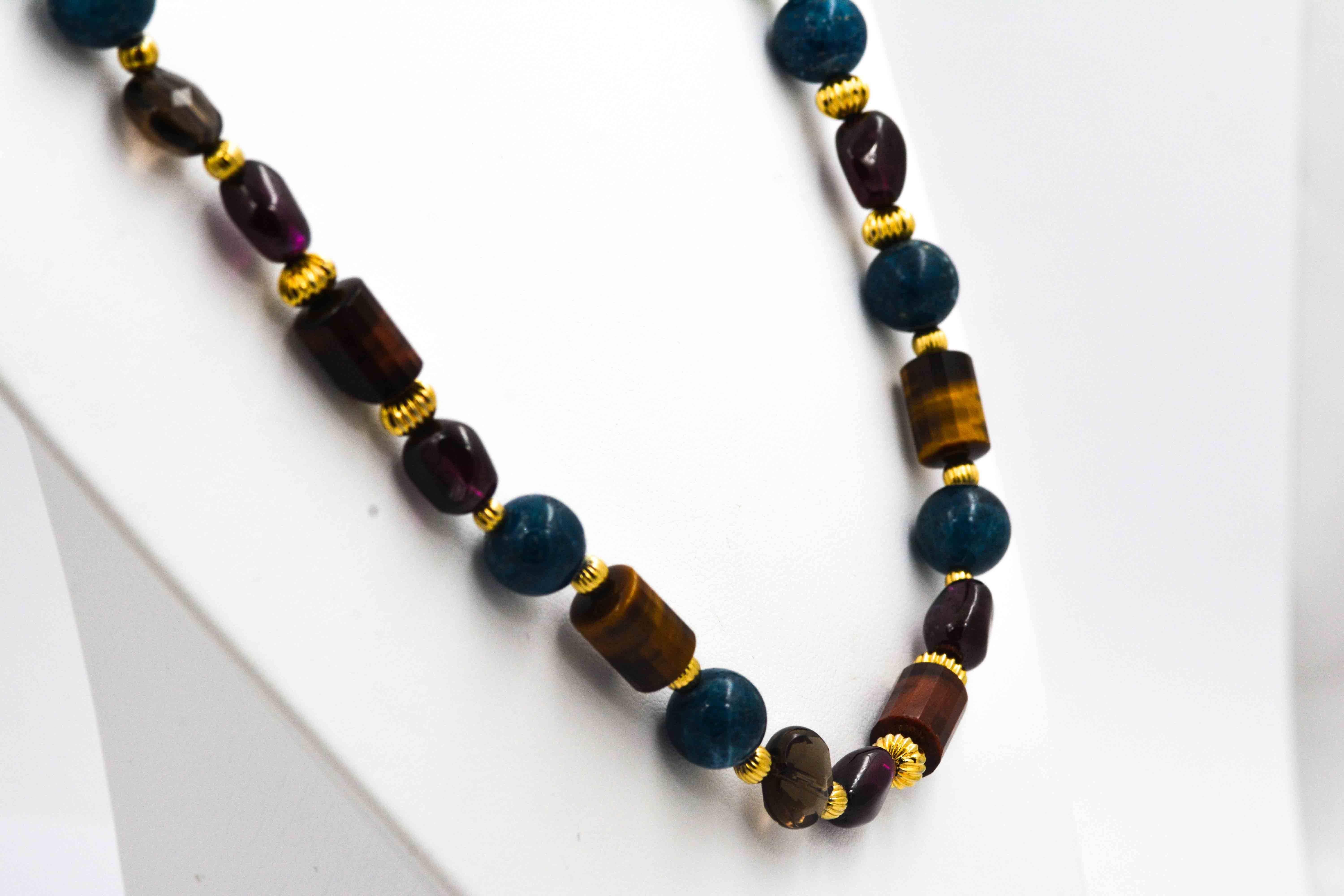 The allure of subtle earth tones on this stunning bead necklace will create calmness and peace. This organic bead necklace is strung with round opaque blue quartz beads, barrel cut tiger eye, tumble polished red garnet, and briolette cut smokey