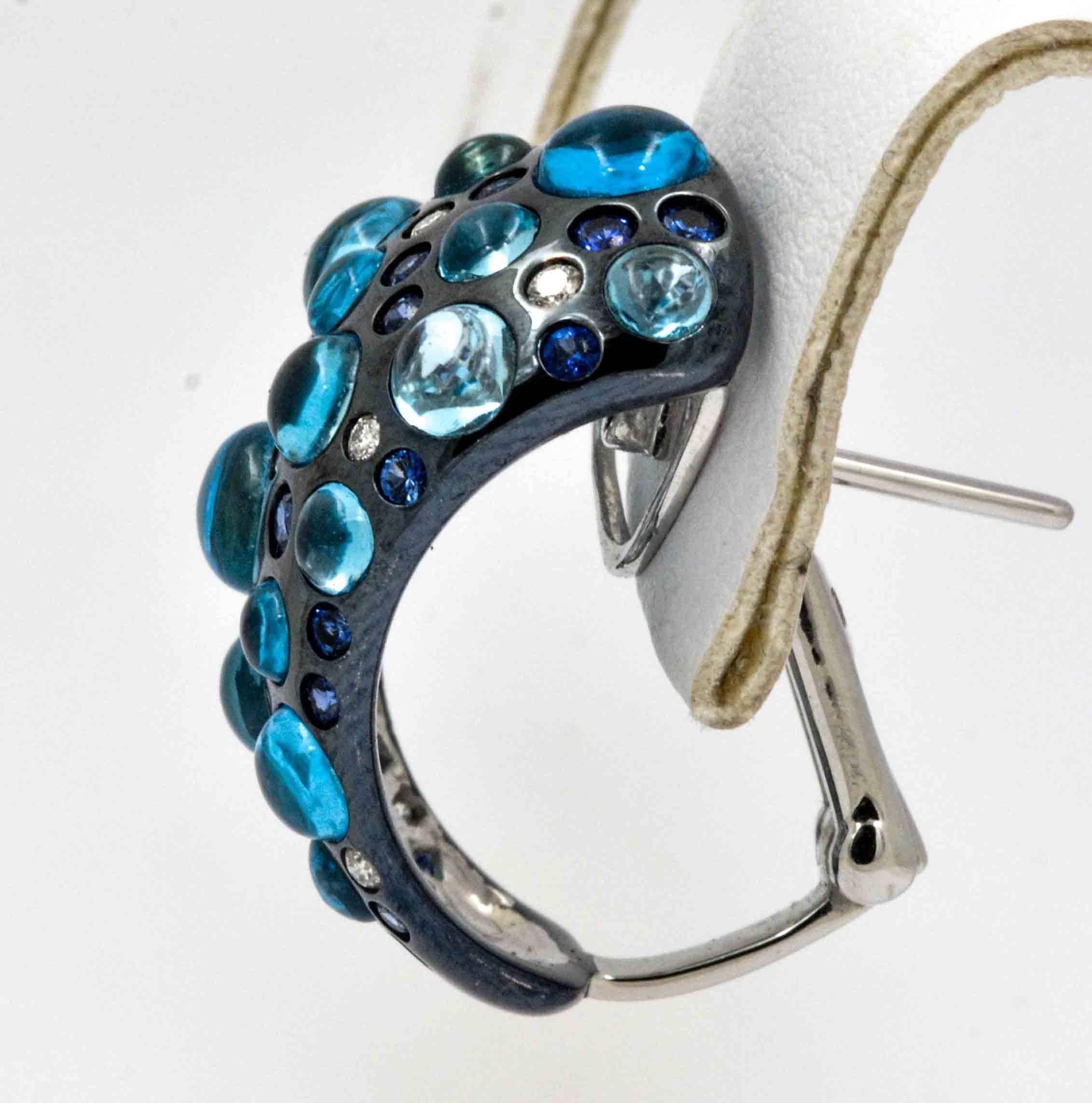 It's all about the dazzle in these Rodney Rayner 18 karat white gold and gleaming black rhodium contrasting majestically in these unique half-hoop earrings. With appealing round, cabochon-cut blue topaz (12.56 carats), tantalizing round
