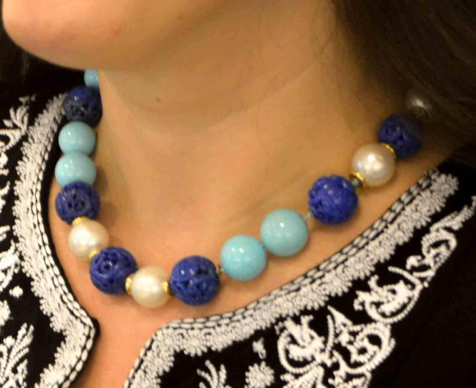 We love all shades of blue and this appealing, one-of-a-kind, Seaman Schepps necklace features intricately hand carved, antique rich blue Lapis beads varying in size from 18.11 mm in diameter to 16 mm in diameter, contrasted with beautiful Sleeping