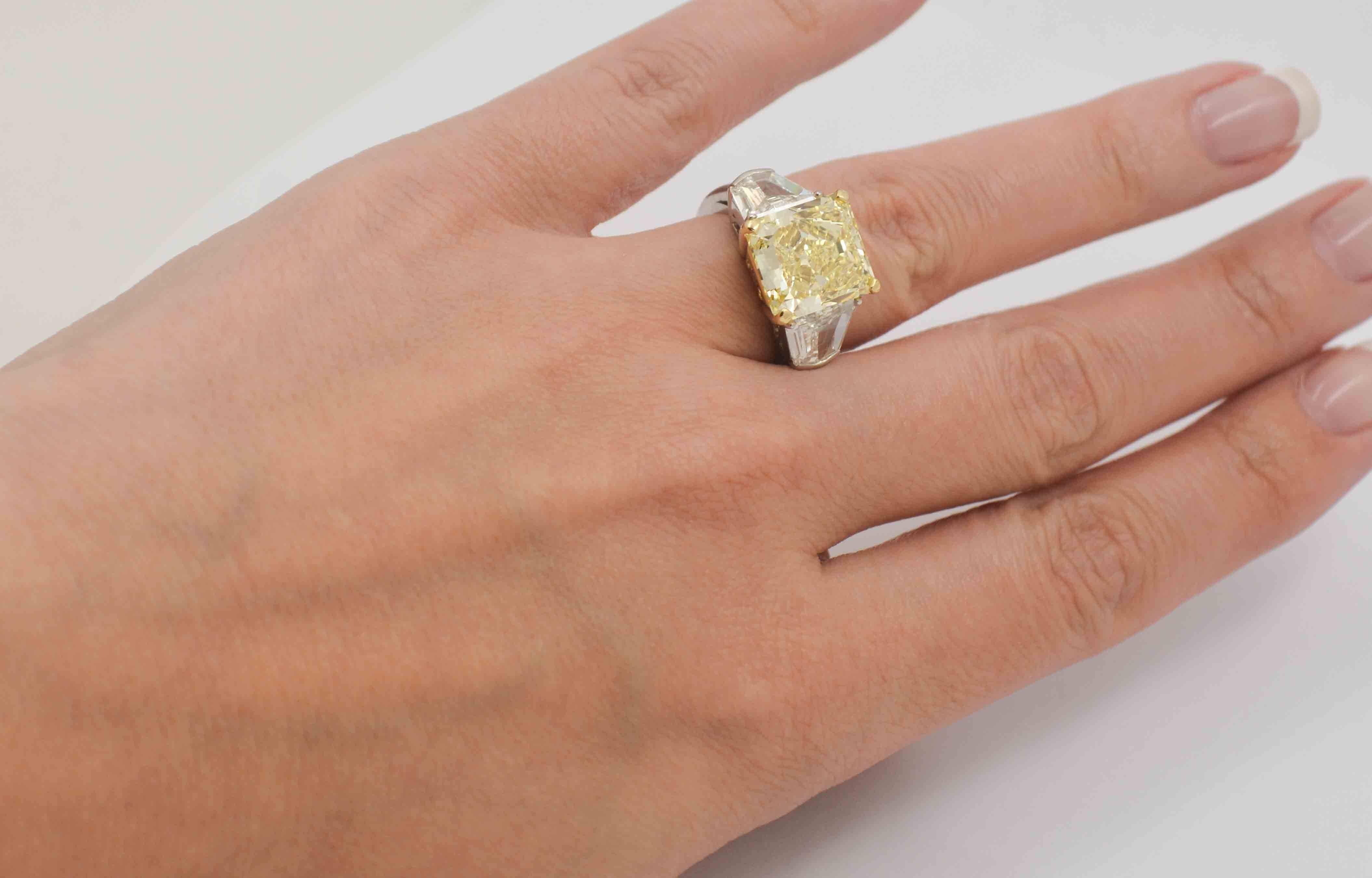 Why not turn heads as you wear this astonishing platinum engagement ring? The center stone is a sensational 8.01 carat natural fancy yellow diamond with an astonishing VVS2 clarity (ring comes with a GIA report).  Contrasting this glamorous center