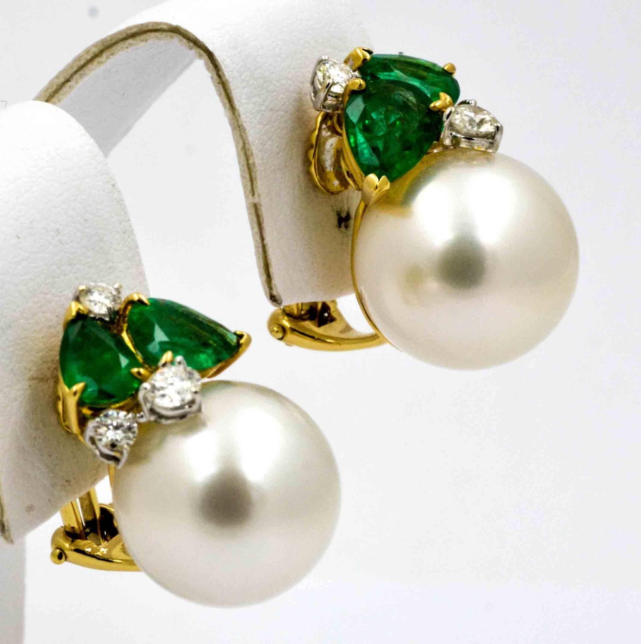 These classic Seaman Schepps earrings feature and amazing matched pair of 14 mm white South Sea cultured pearls.  These pearls have excellent lust and exhibit a beautiful white base color with bluish gray undertones.  The earrings are each accented