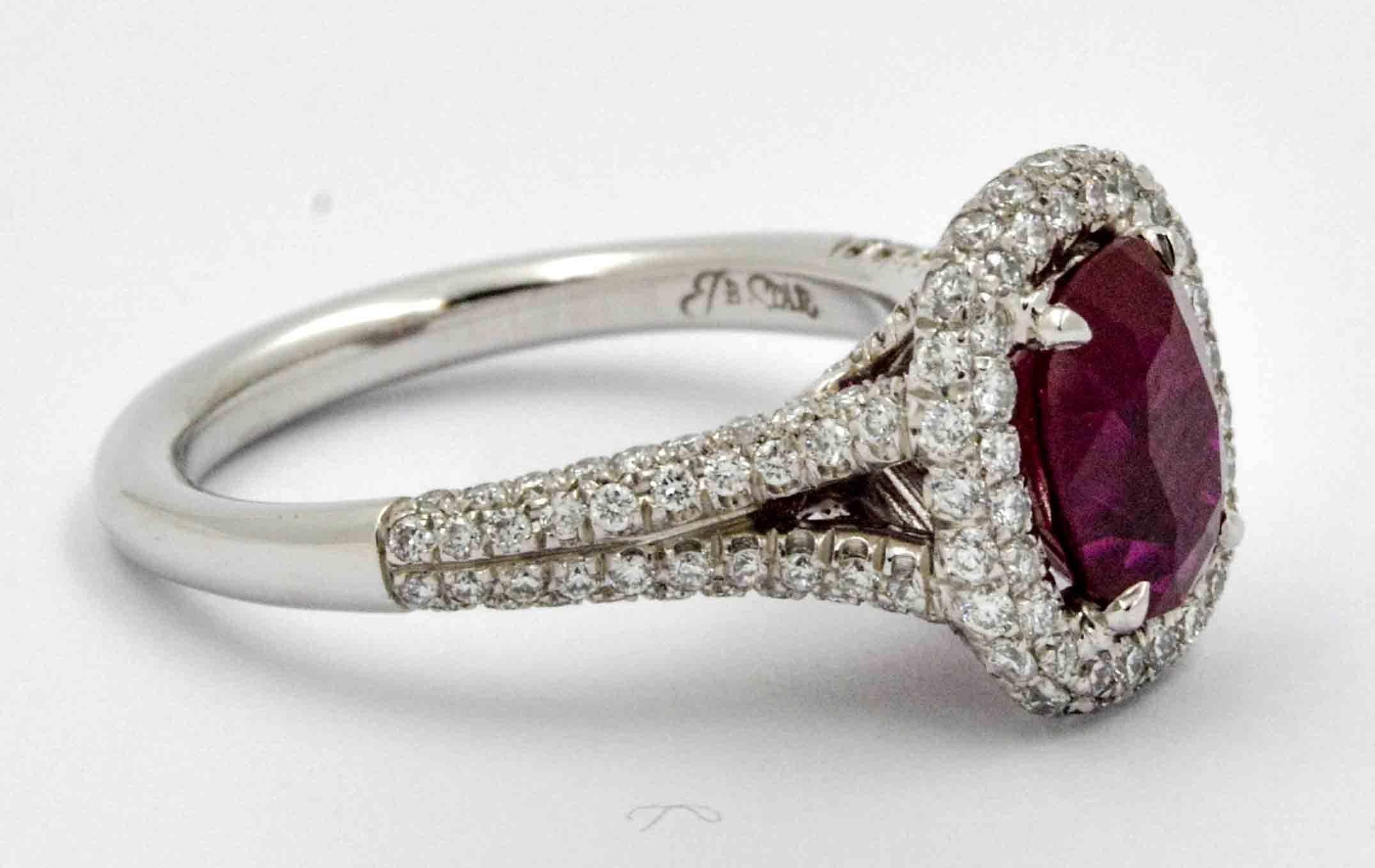 This vibrant JB Star platinum ring features a fine oval ruby, weighing a total of 2.10 carats. The ruby is surrounded by 156 round brilliant cut diamonds in a pave halo and split shank, weighing a total of .85 carats. The diamonds have G-H color and