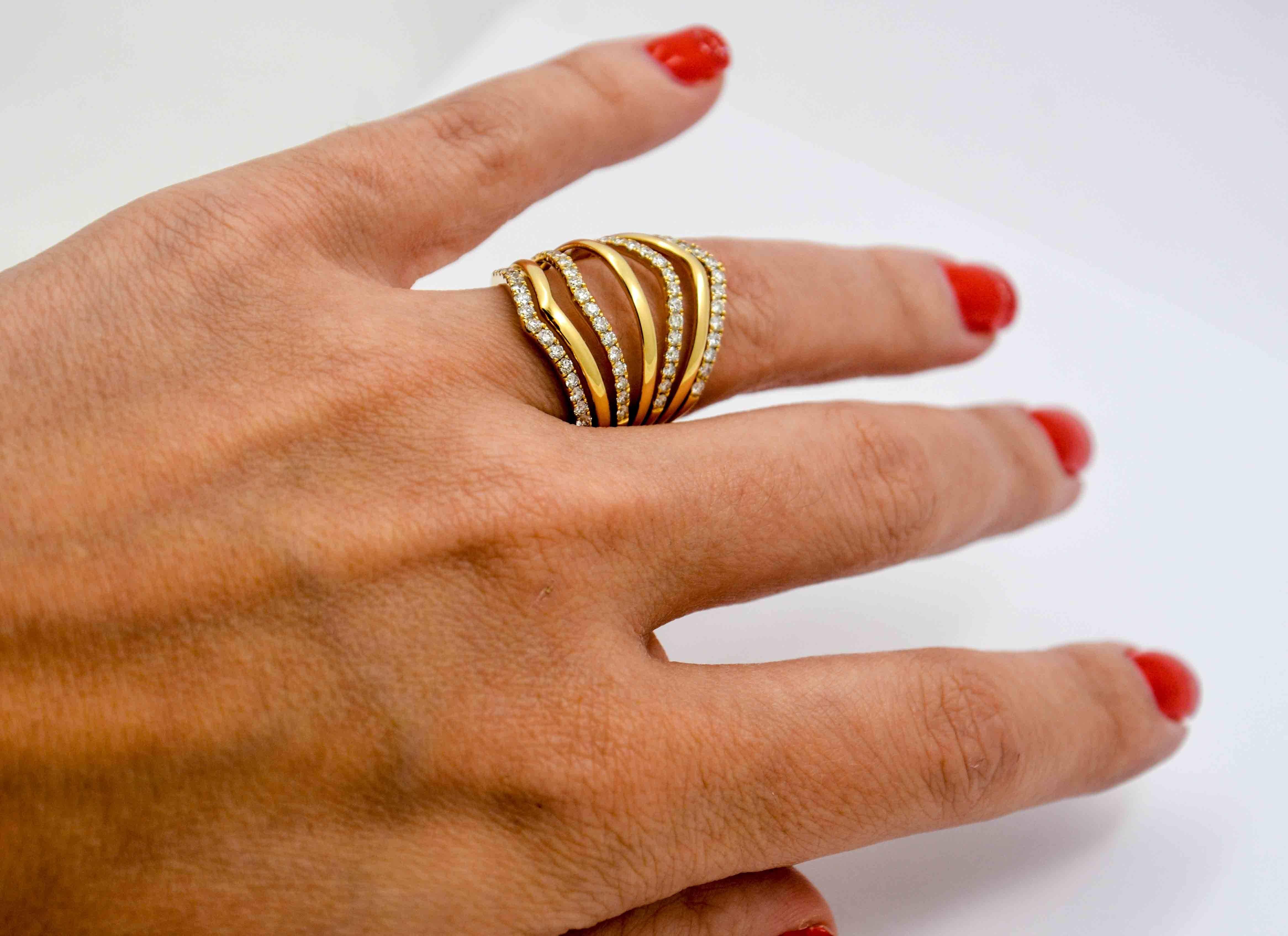 Fanning out like an accordion, this uncommonly impressive 18kt yellow gold and diamond ring is designed in a remarkable seven band split shank design.  The high polish of 18 kt gold contrasts nicely as every other row is set with round brilliant cut