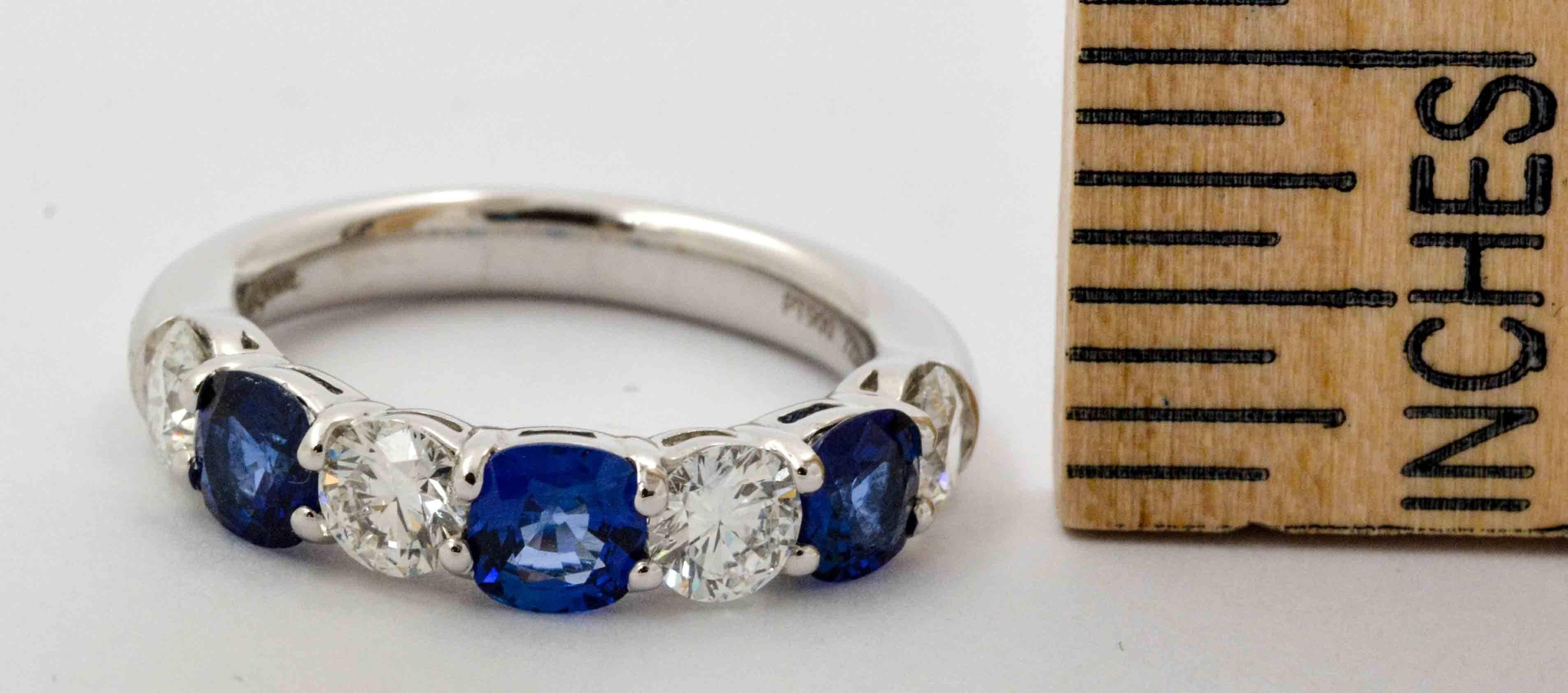 This lovely JB Star anniversary ring showcases three amazing cushion cut vivid blue sapphires which have a combined weight of 1.30 carats total.  JB Star set these amazing blue sapphires next to five beautifully contrasting round brilliant cut