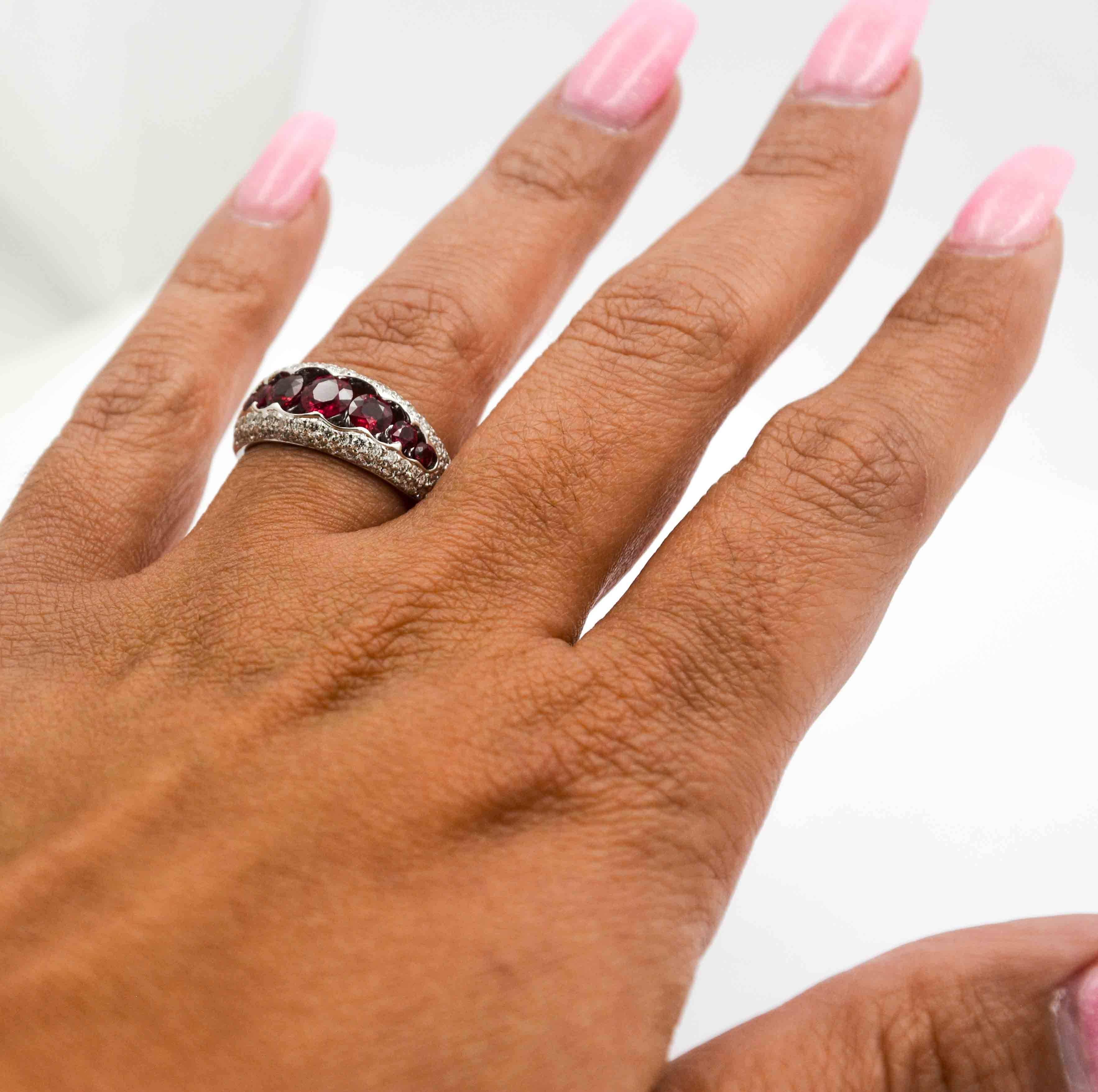 This amazing 18kt white gold ruby and diamond ring is centered with seven round brilliant cut rubies set in an attractive scalloped channel.  The rubies have a vivid saturation with a medium tone.  The color is very intense and vibrant.  The rubies