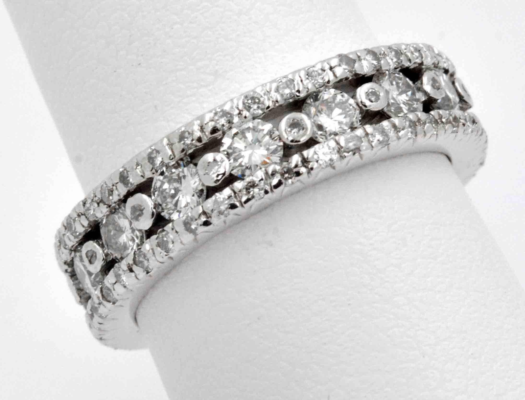 A luxurious 2.24 ct (total weight) sprinkling of diamonds are impressively set in an 18kt white gold eternity band.  This 18 kt white gold ring has intricate rows of round brilliant cut diamonds (G-H color and VS clarity), crafted in a glitzy