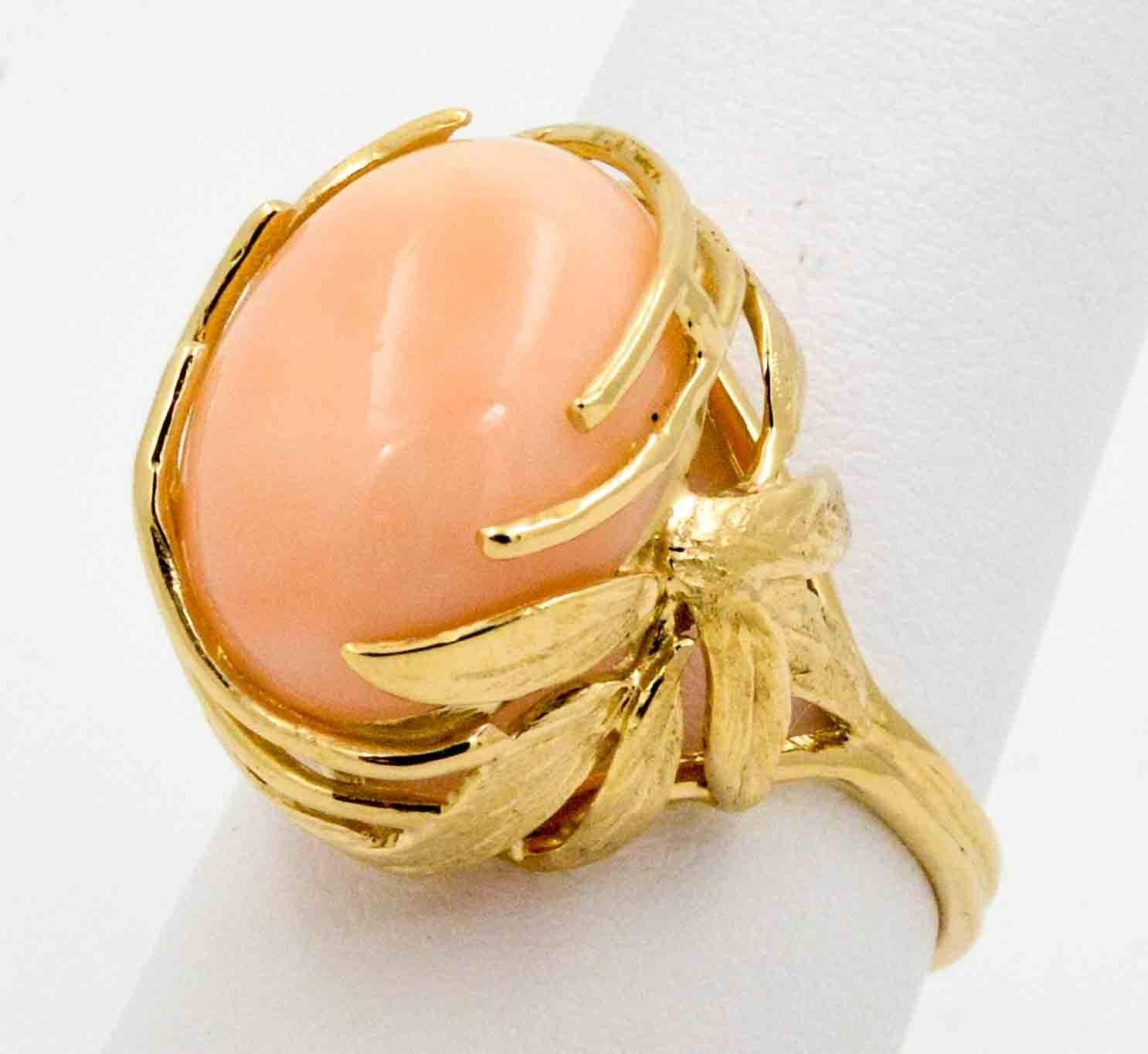 Like a favorite cashmere sweater, this comfortable coral ring is comfortable every time you wear it. This beautiful 14kt yellow gold ring has in its center an angel skin coral cabachon stone. The coral is held in place by a beautiful natural design