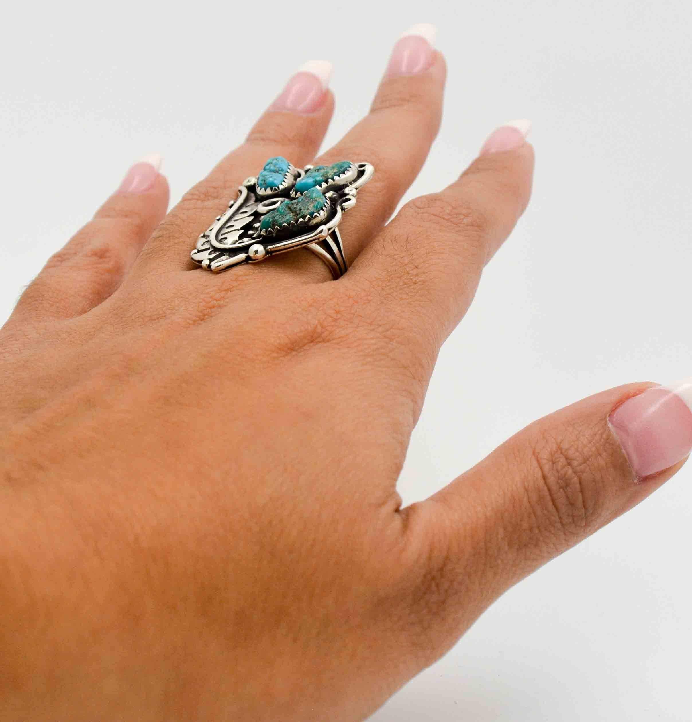 This classic Native American style ring is hand made from sterling silver and turquoise.  The three turquoise used are of a strong blue color and are bezel set.  The silversmith that hand made this ring artfully surrounded the turquoise with