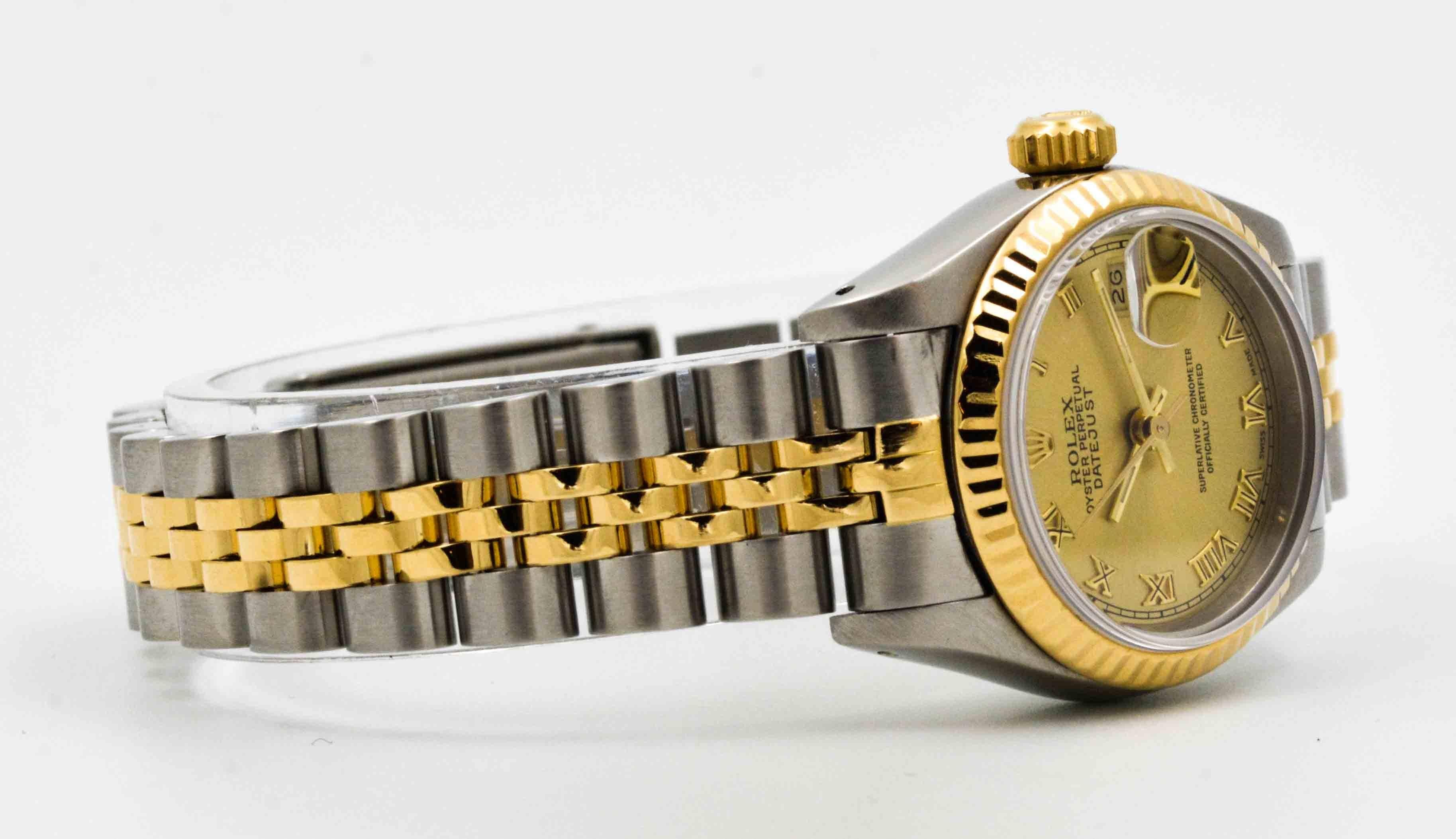The world famous watch company, Rolex, designed this classic 26 mm ladies watch to set off your distinguished style. This DateJust wrist watch of stainless steel, champagne dial and Roman numerals, has a vibrant 18 karat yellow gold fluted bezel.