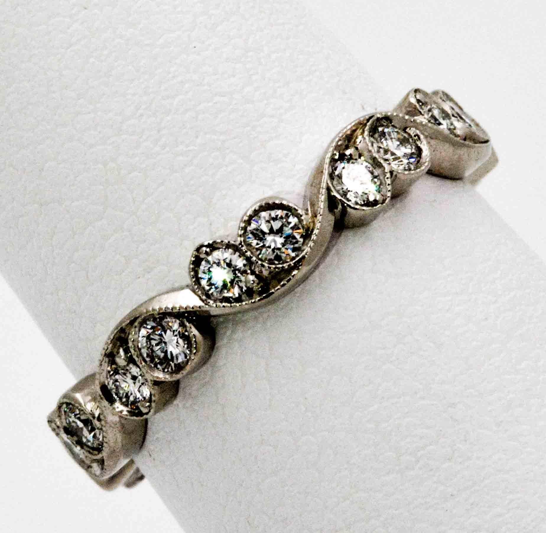  This handcrafted platinum eternity band is simply elegant as it loops and swirls around the finger with 20 round brilliant cut diamonds weighing 0.65 CTW. This irresistible ring fits finger size 5.25, and has far surpassed the Eiseman Jewels