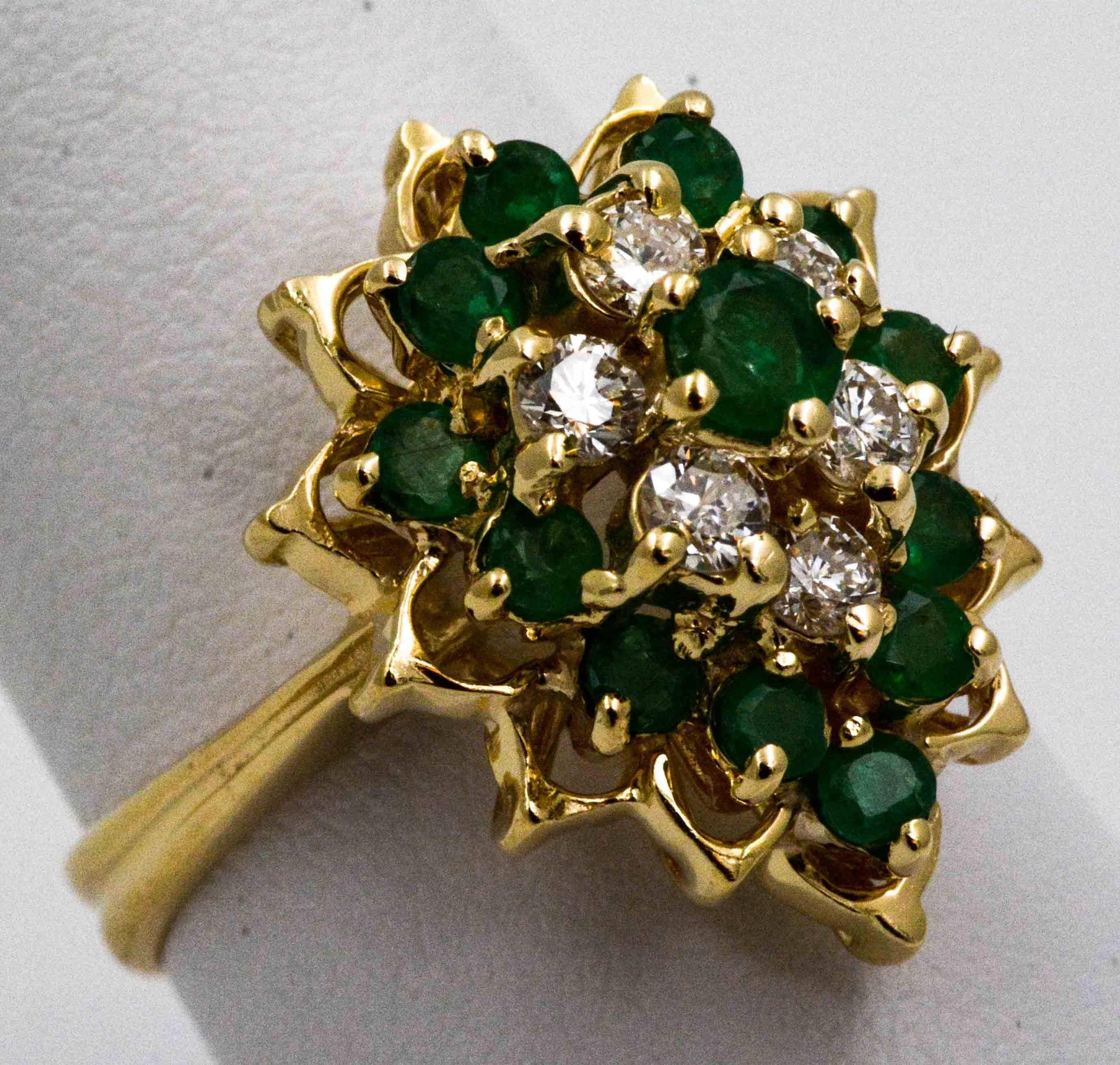 Like a garden of earthly delights, this 14 karat yellow gold cocktail ring has plenty of style. The cluster of alluring diamonds (0.60 ctw G-H color and SI clarity) add scintillating sparkle to the 13 round emeralds (0.50 ctw) in this cocktail