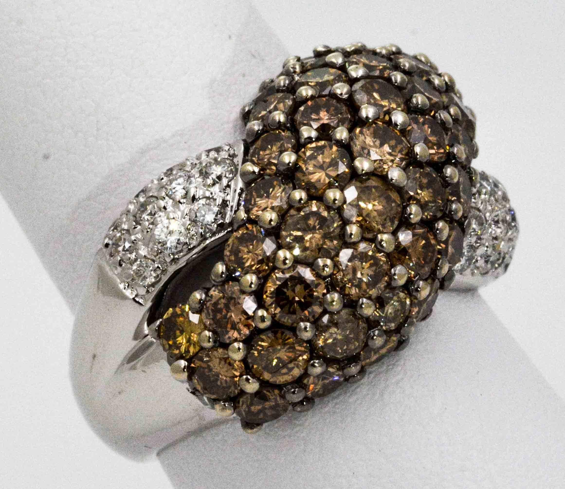 A ring with chocolate diamonds swirling over white diamonds ring is delicious to behold. This 18 karat white gold crossover ring is set with 42 brown round brilliant cut diamonds weighing 4.20 carats (SI-I clarity), along with 22 white round