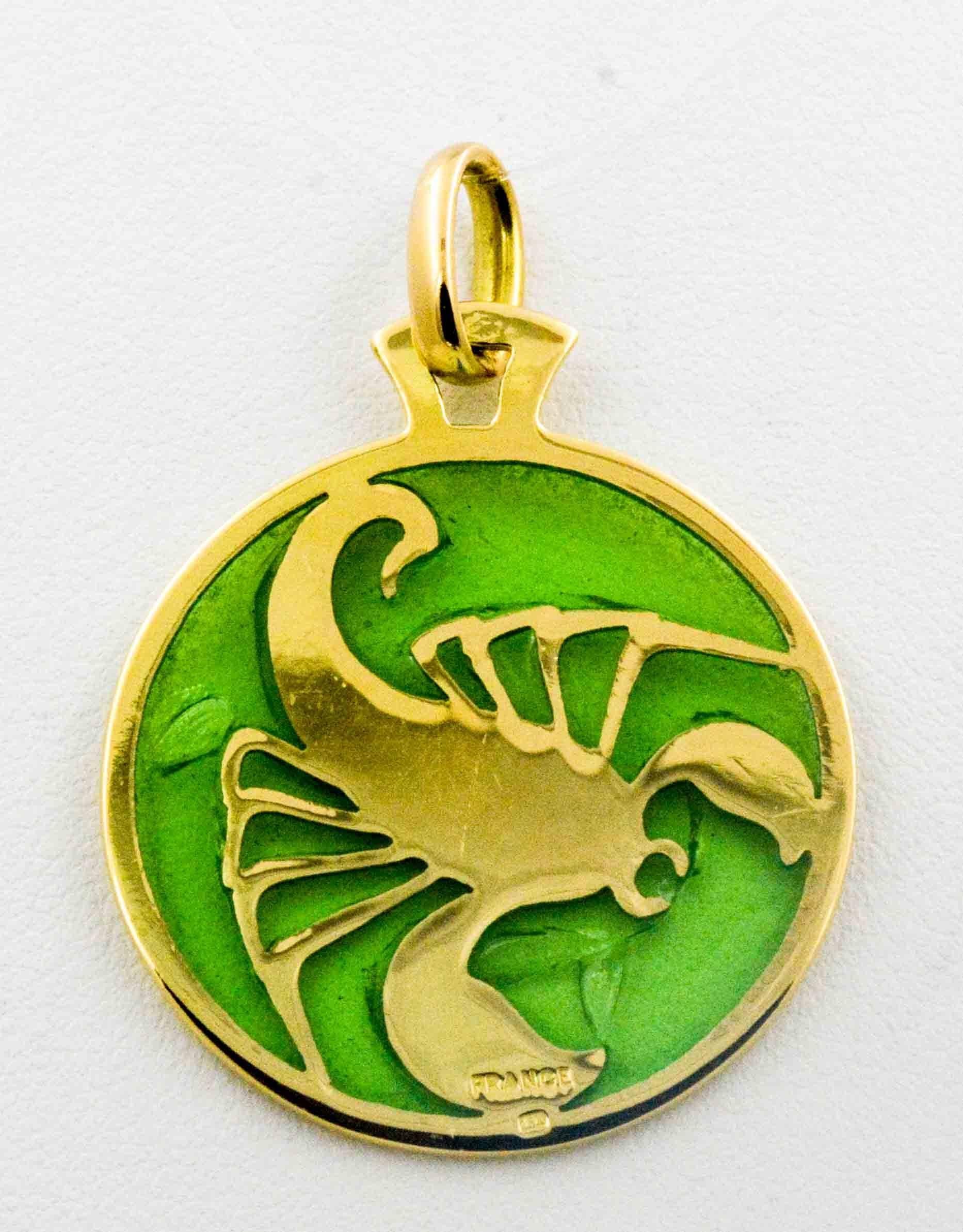 On a brilliant green background of hand enameled glass lies Scorpio, crafted in brown and yellow glass enamel, accented by 18 karat yellow gold. This captivating and delicate little pendant is hand enameled by a master craftsman in the art of Plique