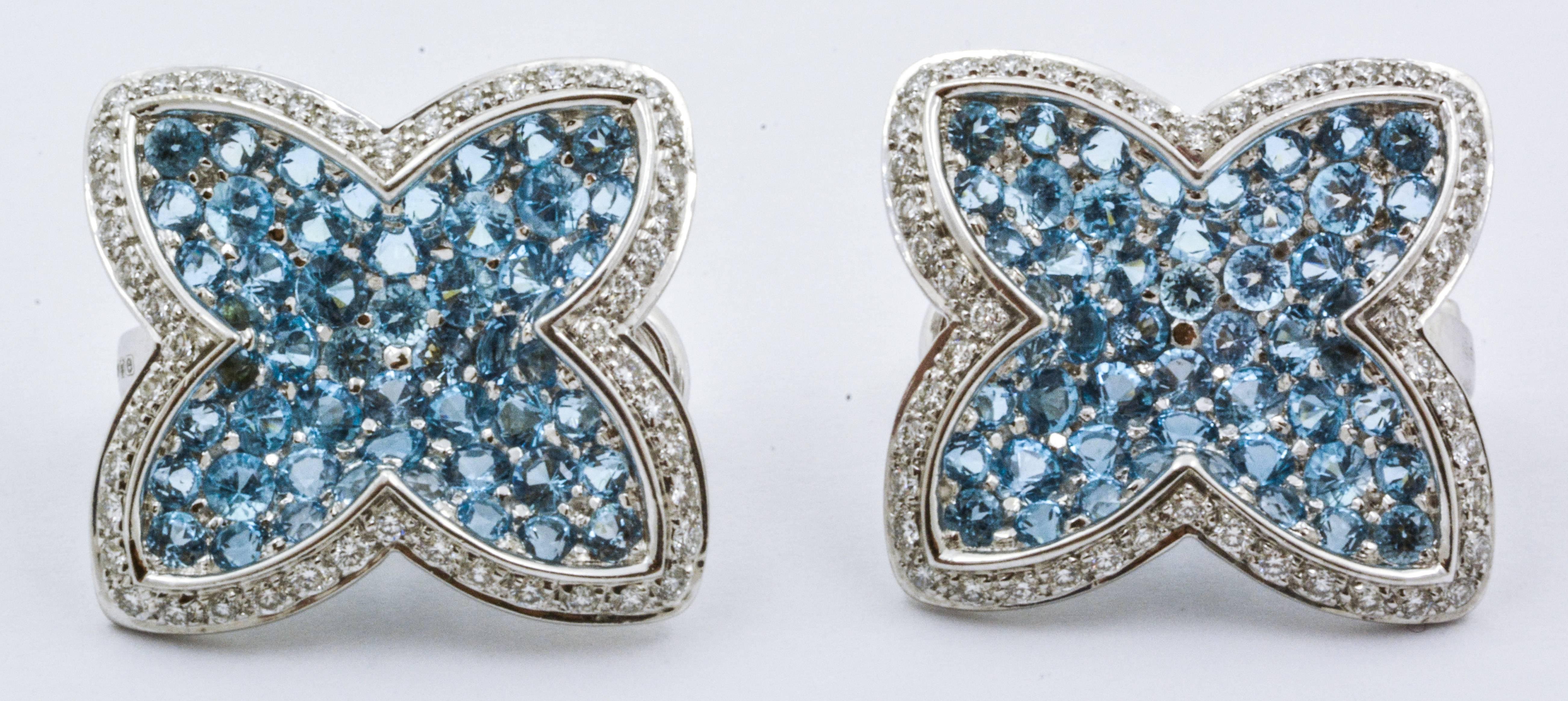 These enchanting Rodney Rayner clip-on earrings feature shimmering 18 karat white gold, sparkling blue topaz, and lovely accent diamonds. The blue topaz gems weigh approximately 5.52 carats combined, while the diamonds are approximately 0.89 carats