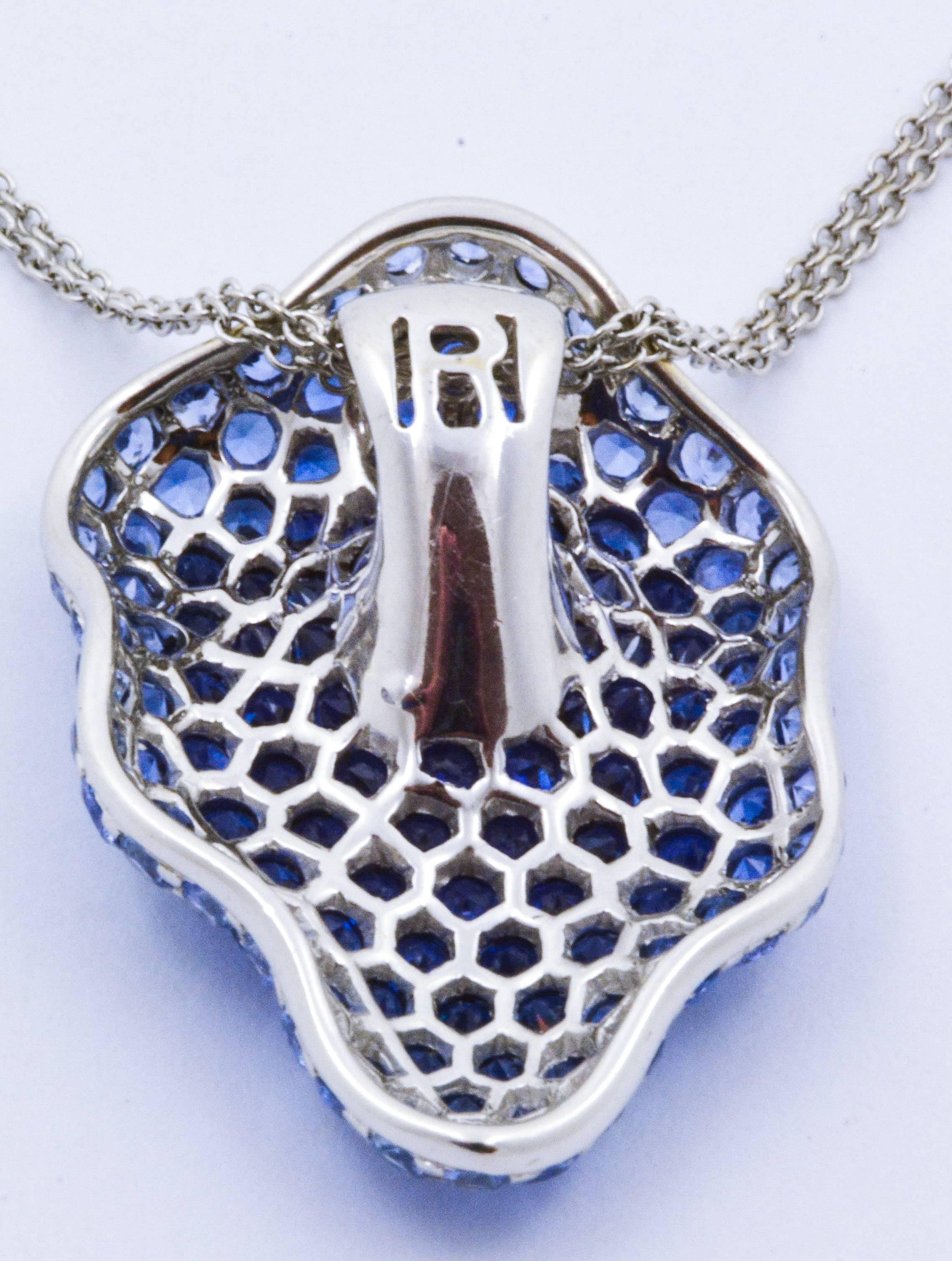 Enhance the neckline with a touch of magnificent blue in this pendant created by Rodney Rayner. 7.40 carats of strikingly beautiful round brilliant cut sapphires flow flawlessly over a contoured surface, creating a sparkling and organic piece of art