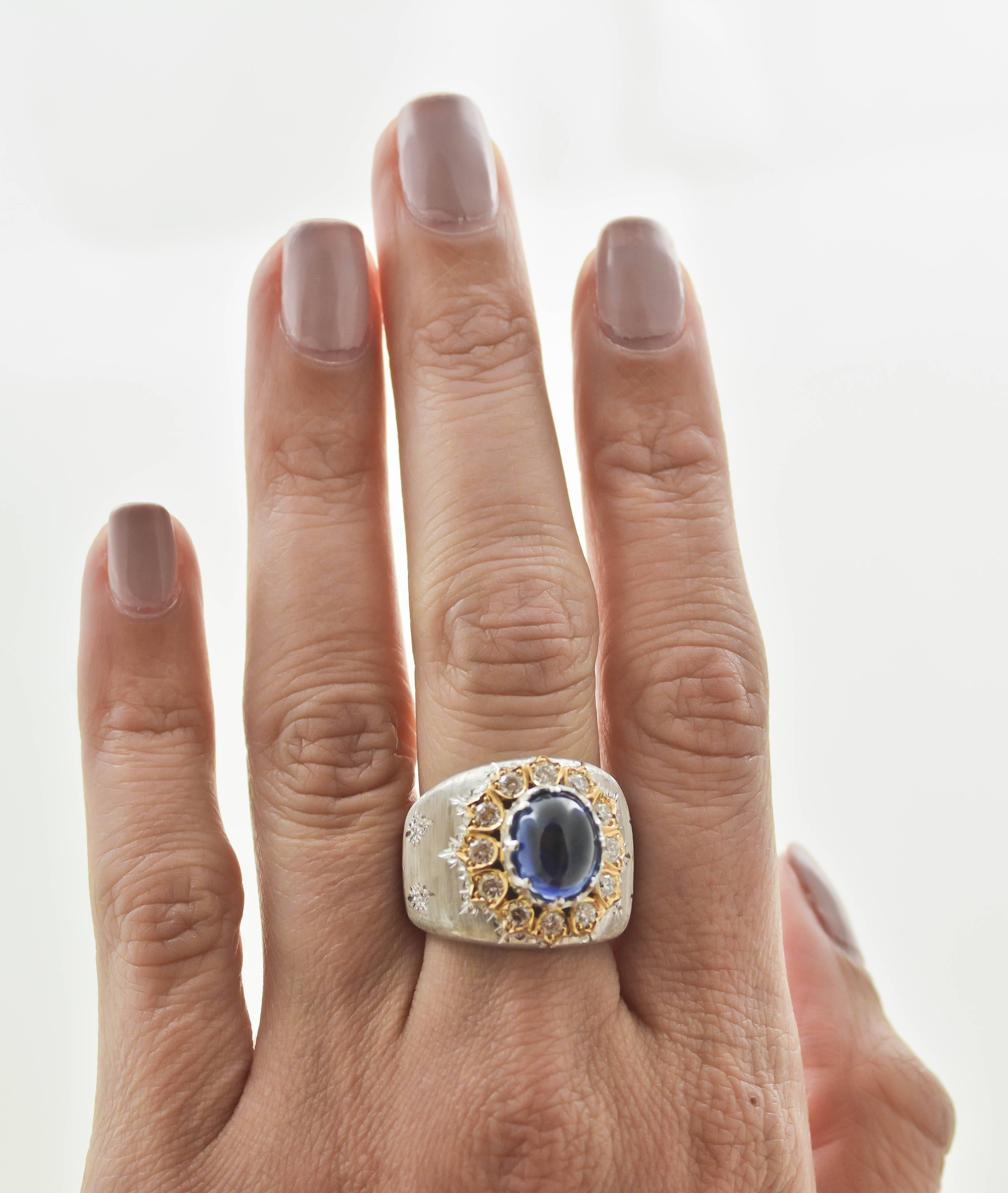 You don't have to be royalty to wear this boldly provocative two color gold ring. A 5.00 carat oval cabochon cut deep blue sapphire is accented with twelve round brilliant cut diamonds, weighing a combined 0.74 carats, with G-H color and VS clarity,