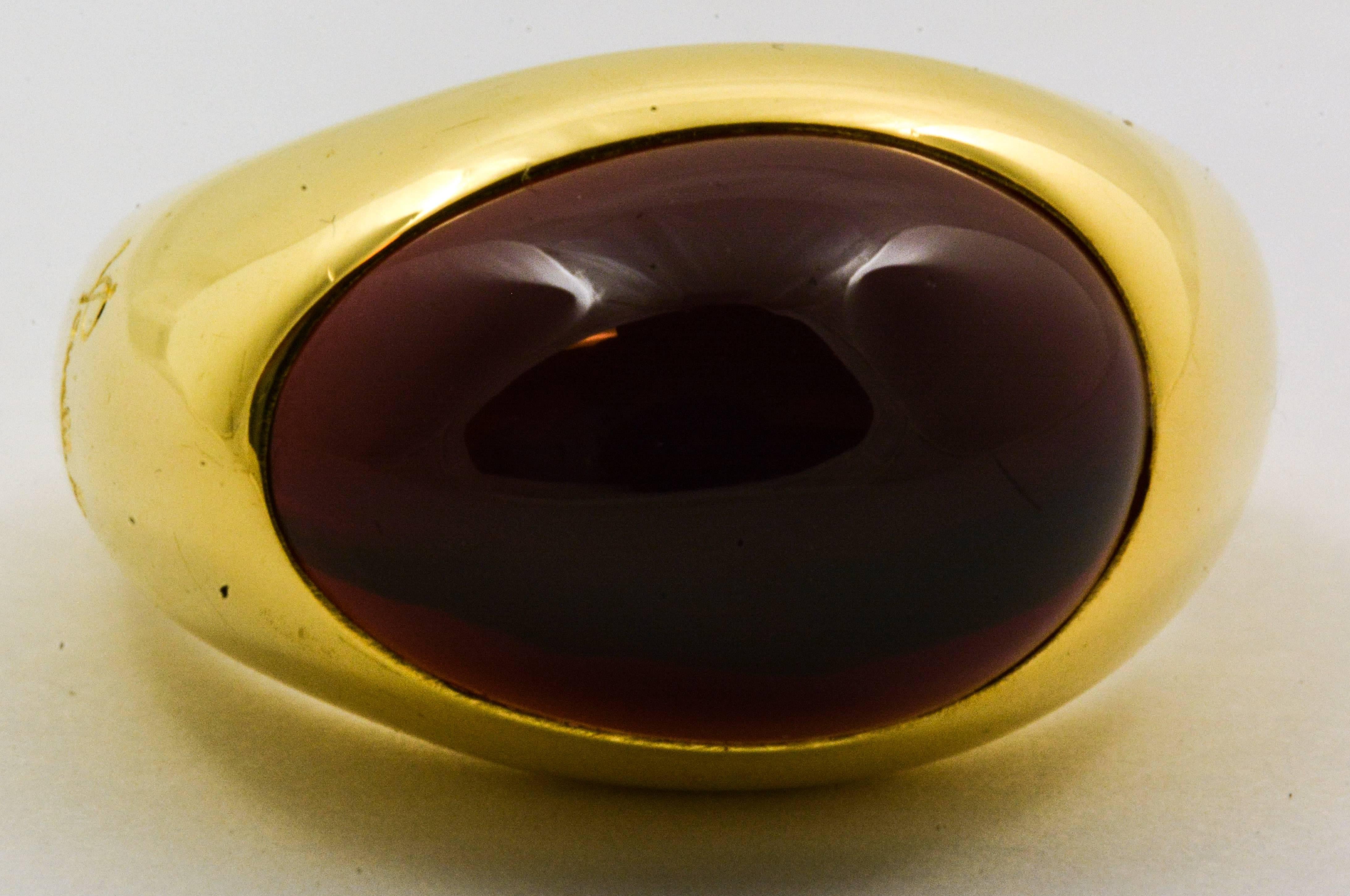 A gorgeous oval cabochon cut garnet weighing approximately 8.53 carats is the eye-catcher of this beautiful 18kt yellow gold estate Pomellato ring. With the designer’s name signed prominently on the side, this ring is unmistakably unique. It