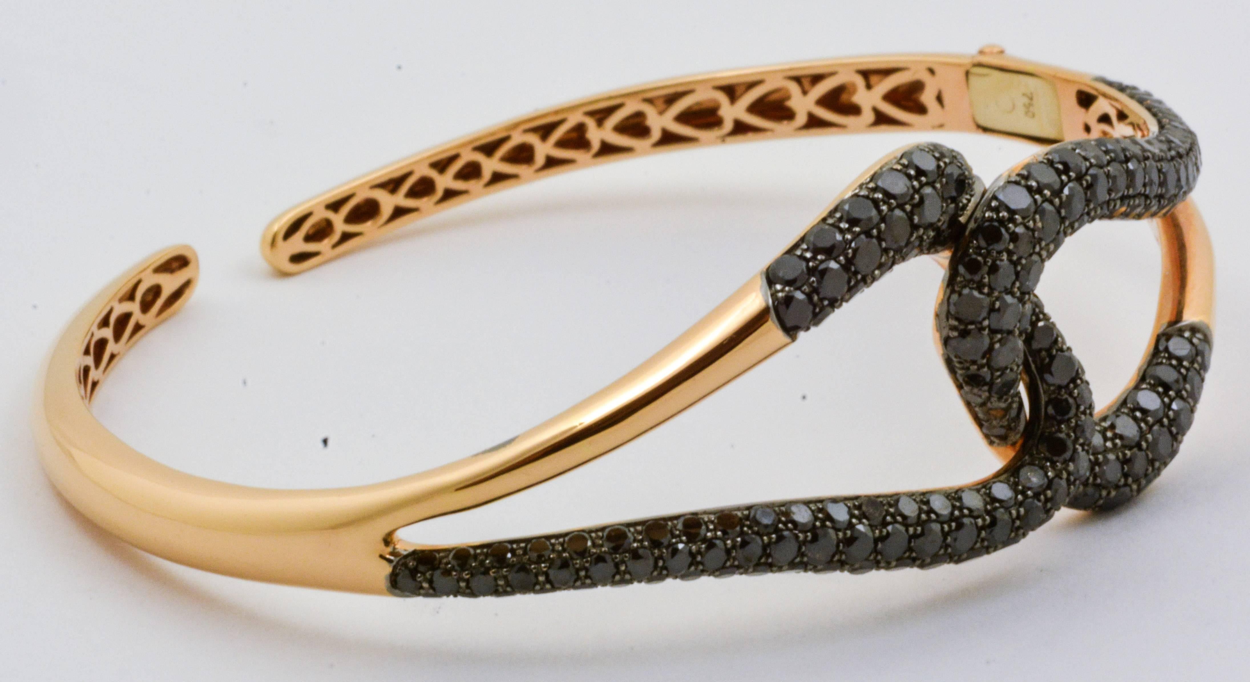 This organically shaped Etho Maria bangle bracelet is a singular piece. Artfully crafted with 18 karat pink gold and 4.60 carats of round brilliant cut black diamonds. This unique composition clasps with a spring hinge as a beautiful accent on the