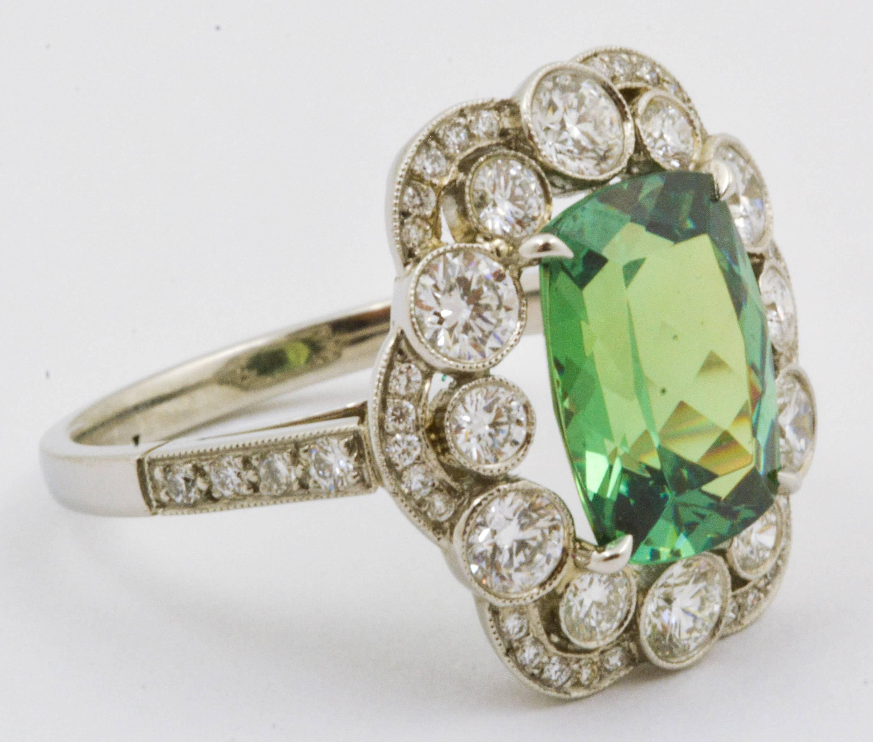 This matchless Tsavorite ring is a singular piece of jewelry whose bright 3.92 carat Tsavorite garnet will catch any eye. Delicately designed with platinum and 1.21 carats of bezel set diamonds (internal clarity VS color G-H) as a halo about the