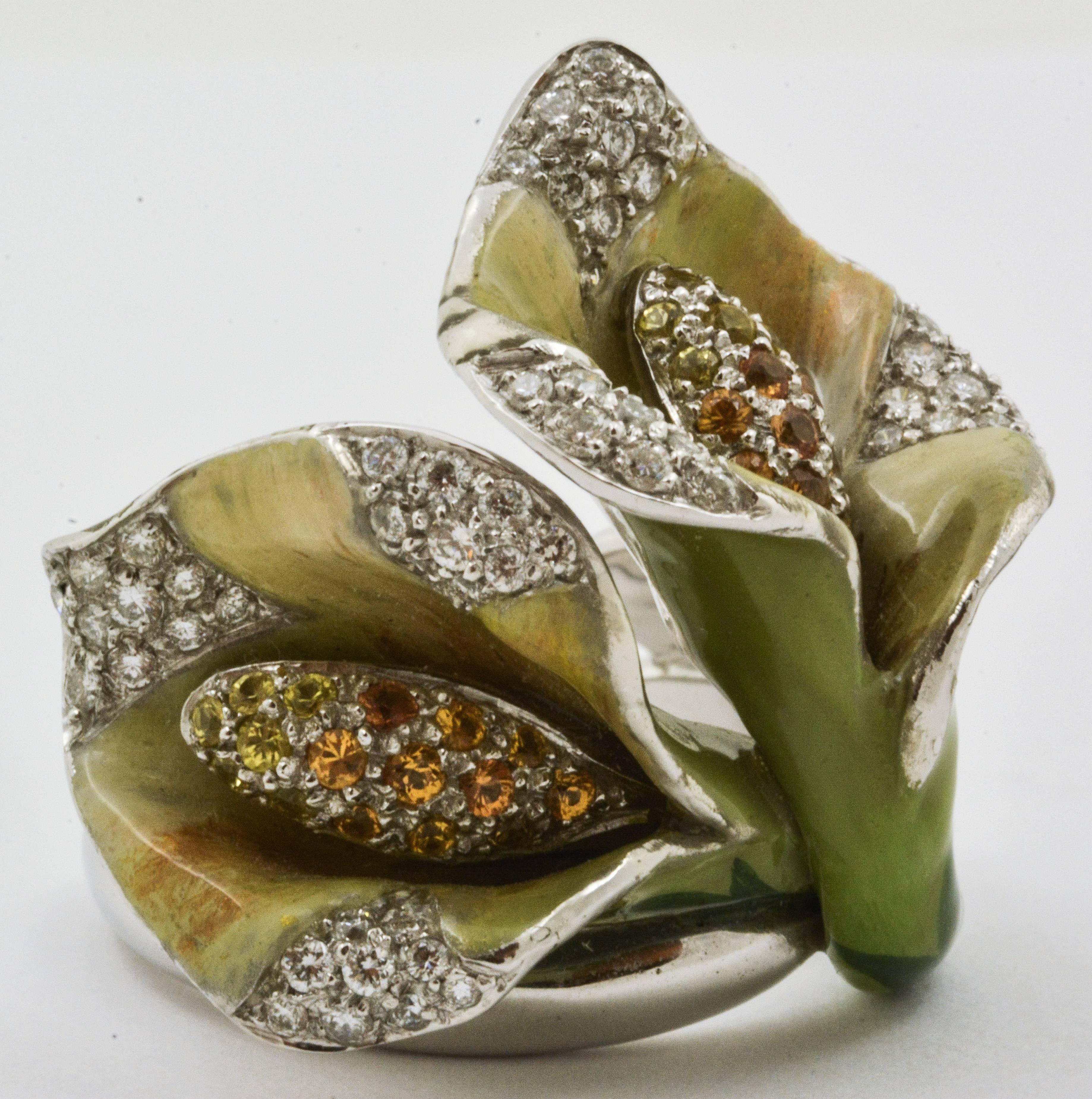 A greenish enamel renders this Calla Lily Flower ring extraordinarily lifelike. The edges of the design are pave set with round brilliant cut diamonds (weight 0.57 carats, internal clarity VS, color G-H), which draw the eye towards the orange and