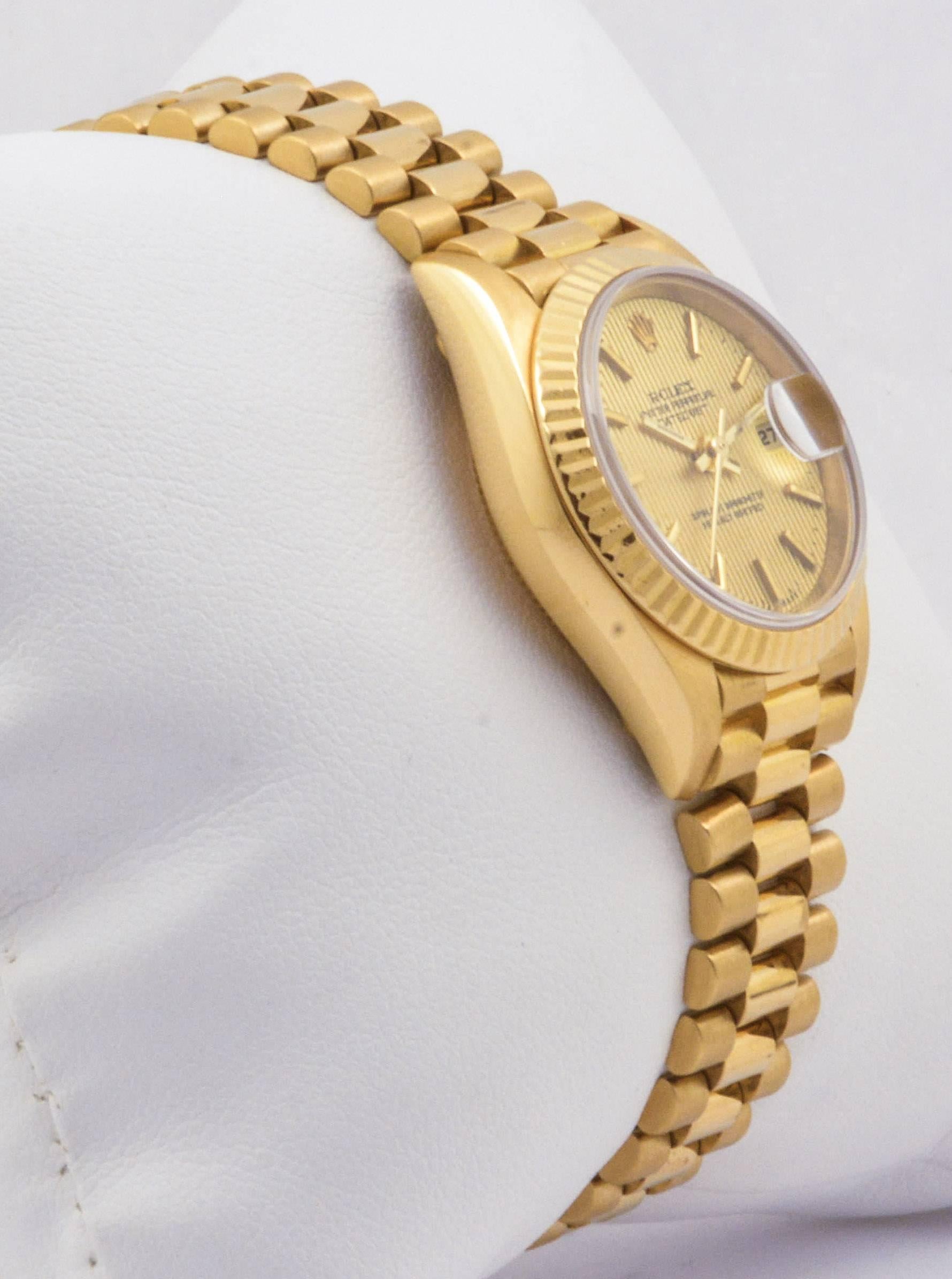 This 1995 vintage 26mm Rolex watch is in excellent condition. Fashioned from 18kt yellow gold, this Presidential Rolex features a champagne dial with index dial markers, a sapphire crystal, a fluted bezel, and is complete with a jubilee bracelet.