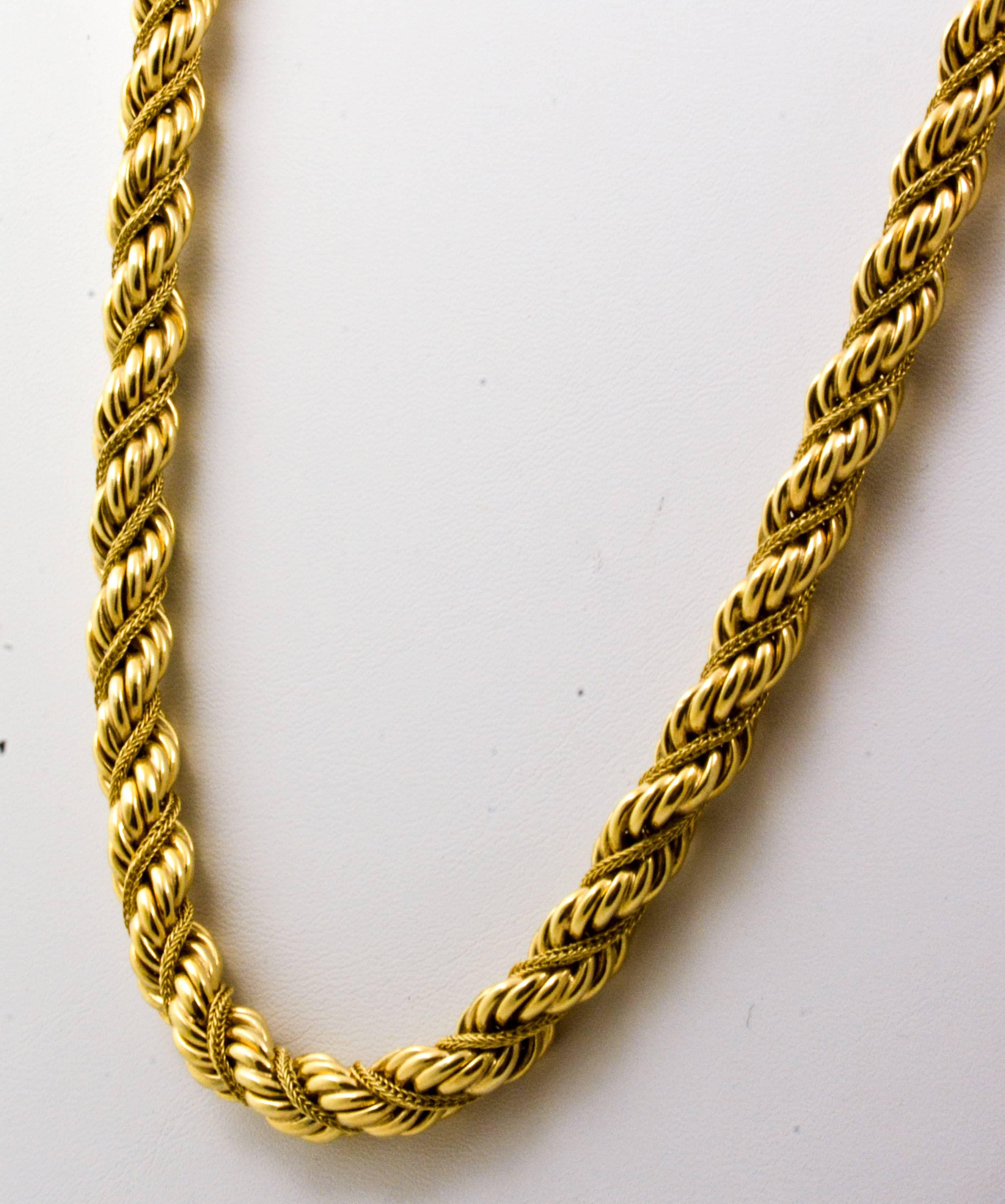 This 14kt yellow gold necklace measures 7.8mm in diameter. The 14kt gold is highlighted with a lovely box chain wrapped tightly in a spiraling rope 15.5 inches in length. Elegant in its simple design, this braided rope necklace is sure to complement