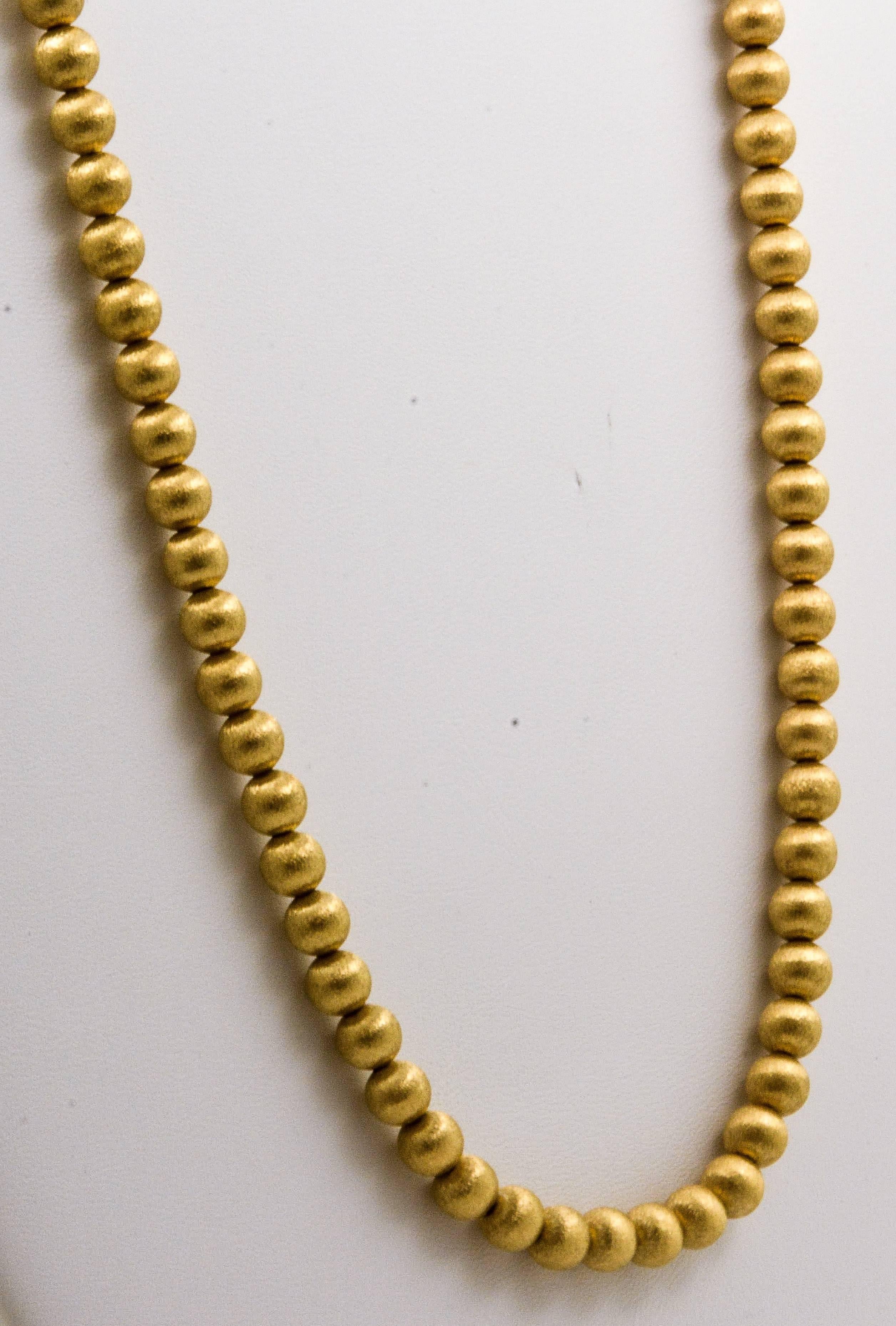 Sixty-six round 6.25mm textured beads fashioned from stunning 14kt yellow gold make this estate gold bead necklace a must-have. Strung on a 16in chain, these beads stand out with a brilliantly designed satin texture that sets this necklace apart and