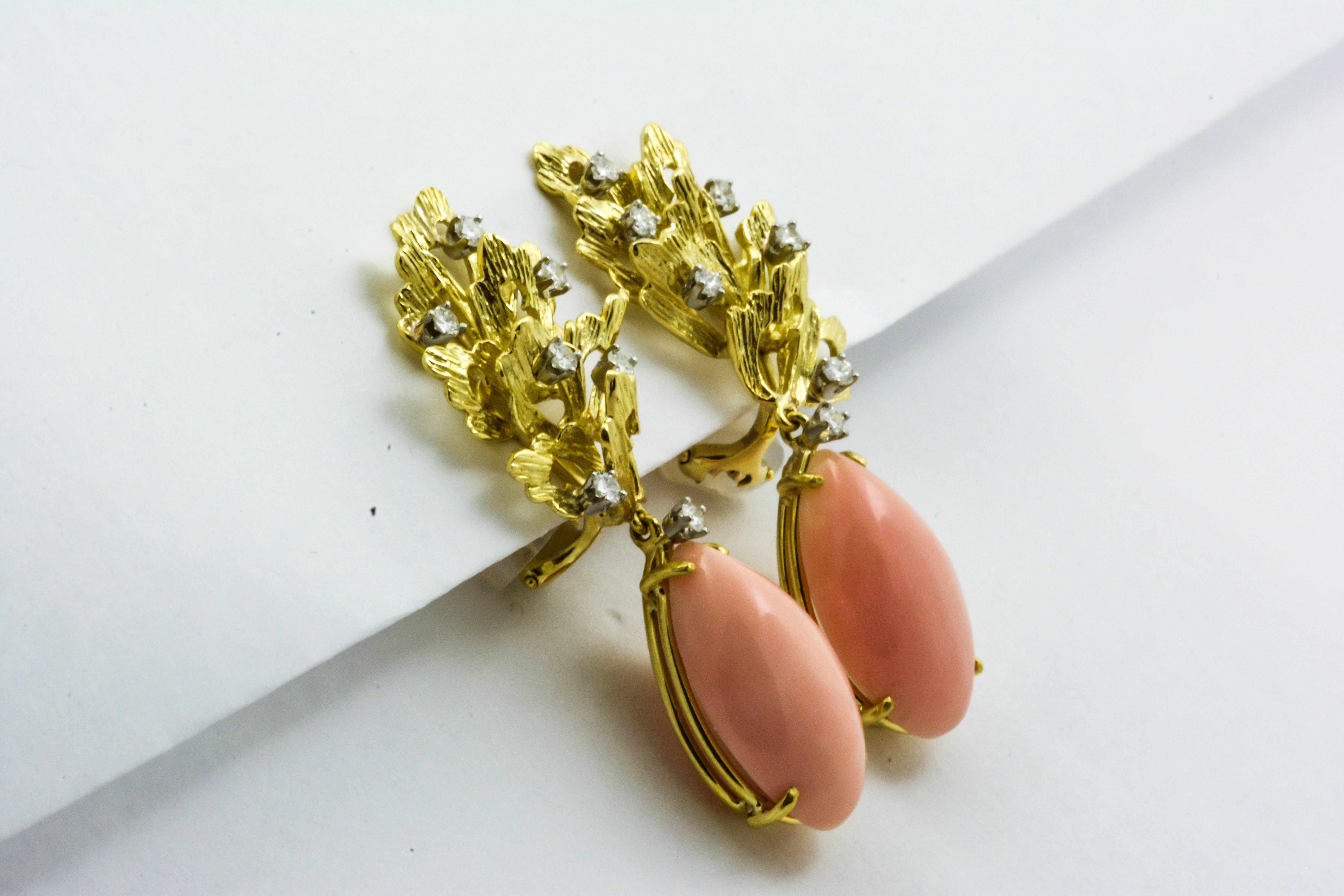 Two Angel Skin coral cabochon cut gems are stunningly displayed in these 18kt yellow gold Tiffany and Co. pair of clip-on earrings. The gems have an impressive combined weight of 28 carats and measure 22x12.8x7.7mm. The two coral gems dangle from a