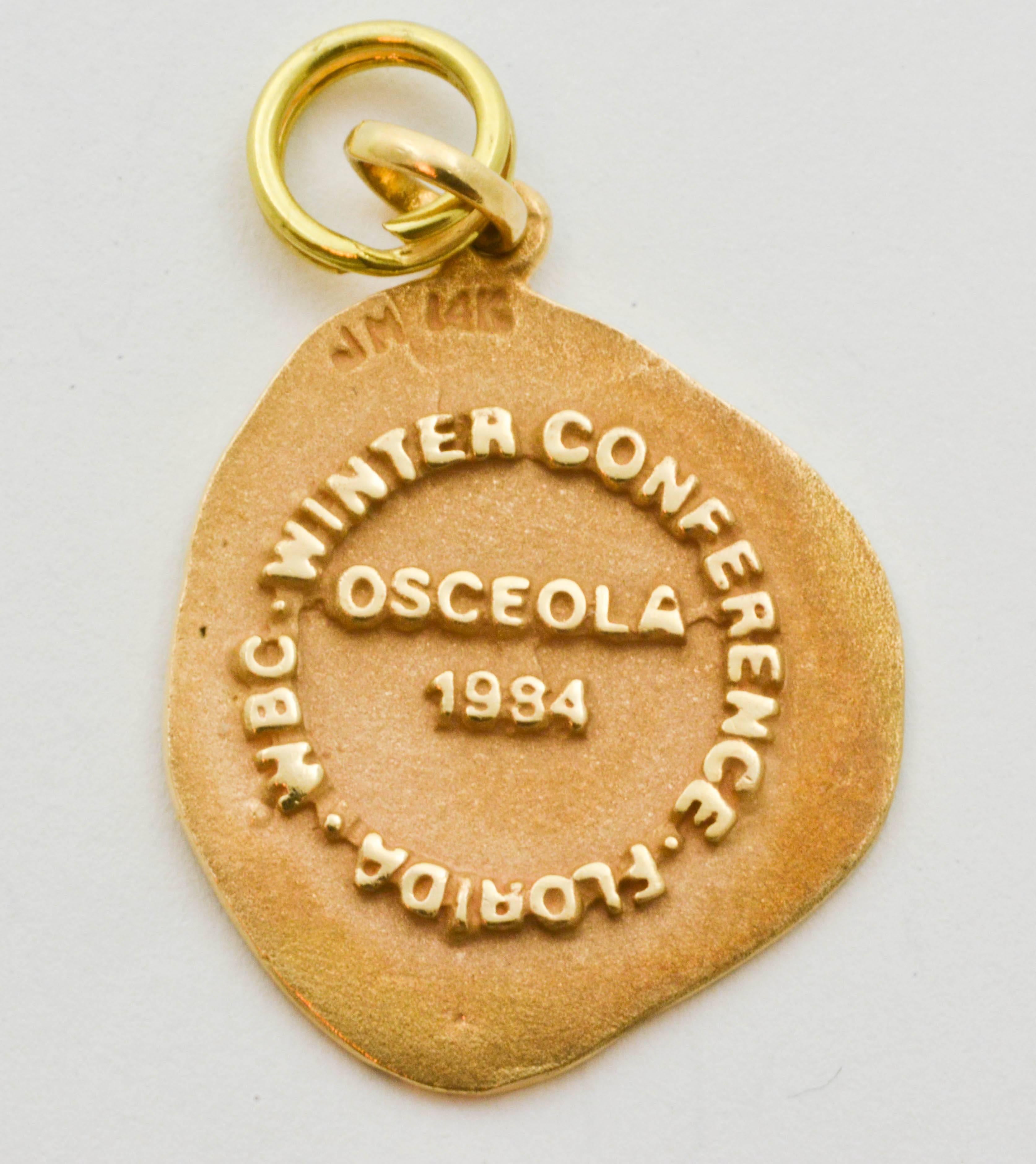 Carved in low relief, the regal image of a Native American is the feature of this 14 karat yellow gold charm. The reverse side is embossed with the words, “Winter Conference Florida WBC Osceola 1994.” Measuring 21.17x18.9x1.58mm and weighing 3.7g.