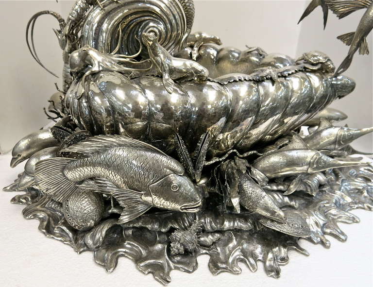 An absolutely stunning, highly detailed and unique sterling silver centerpiece made in Milan, Italy by Buccellati, in the form of a mermaid driving a wave-form chariot, the shaped wave base set with sea and clam shells, mussels, dolphins, coral and