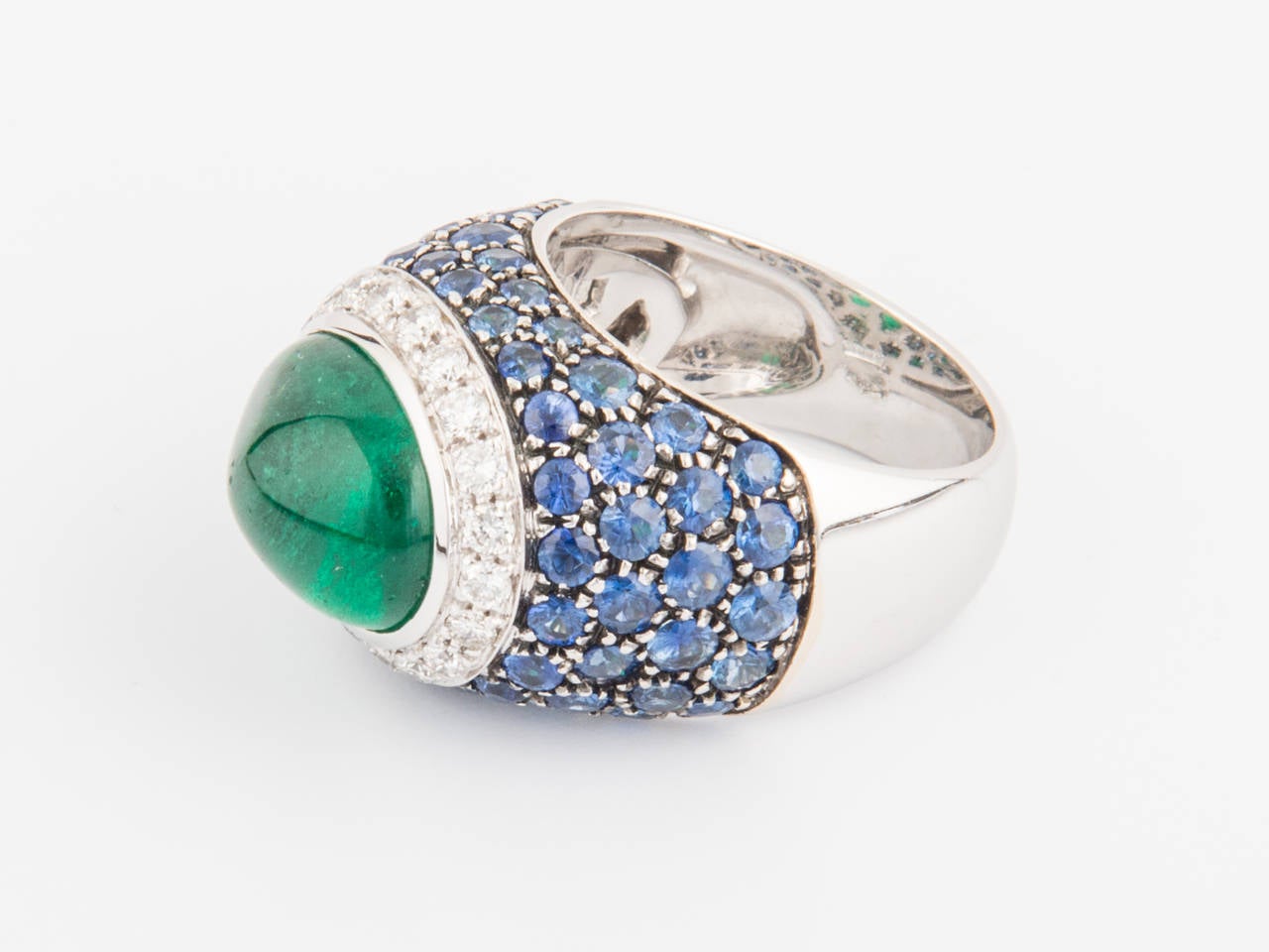 Ring-One of a Kind-18Kt white gold, mounted with a superb Oval Cabochon Emerald weighing 6.77 carats, round diamonds weighing 0.54 carats & round sapphires weighing 3.68 carats.

Finger size 6 1/2 (US size) or 53 1/2 (European size)