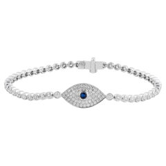 Bracciale con occhio malvagio in diamanti incastonati a pavé, in oro bianco 18 carati con zaffiro blu come dettaglio