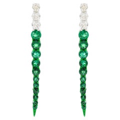 Pendientes largos con esmeraldas redondas ligeramente cónicas y diamantes, en oro blanco de 18k