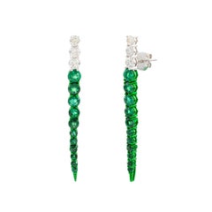 Pendientes largos con esmeraldas redondas ligeramente cónicas y diamantes, en oro blanco de 18k