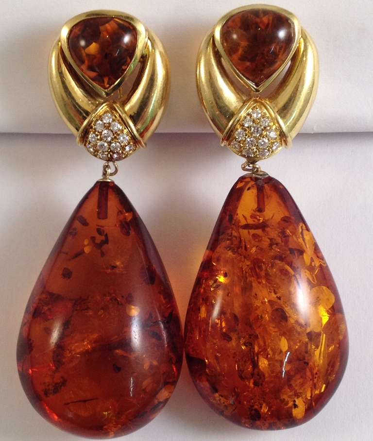 18kt yellow gold large smooth teardrop shape beautiful color and lustre amber earrings composed of 2 carat each custom cut cabochon triangular cut ambers on top and embellished with . 75 carat of high quality full cut diamonds and made with 2