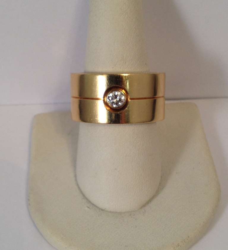18 Kt. Yellow Gold And Diamond, Wide Band With Split Seam, Centering A Bezel Set  .20 Ct. Full Cut, High Quality Diamond. Signed, Cartier, Made In France, Circa 1990's. Ring Size 9.