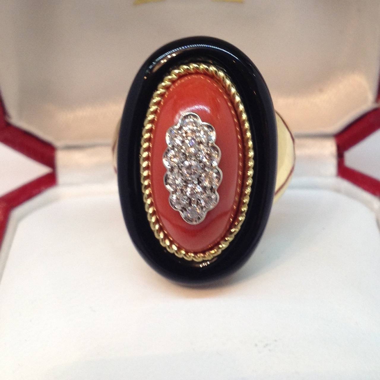 !8Kt Yellow Gold Oval Shape Cocktail Ring Consisting of One Large Beautiful Color Oxblood Coral Bordered By A Custom cut Highly Irridescent and polished onyx embellished with 14 full cut diamonds and set in a high polish yellow gold mounting
