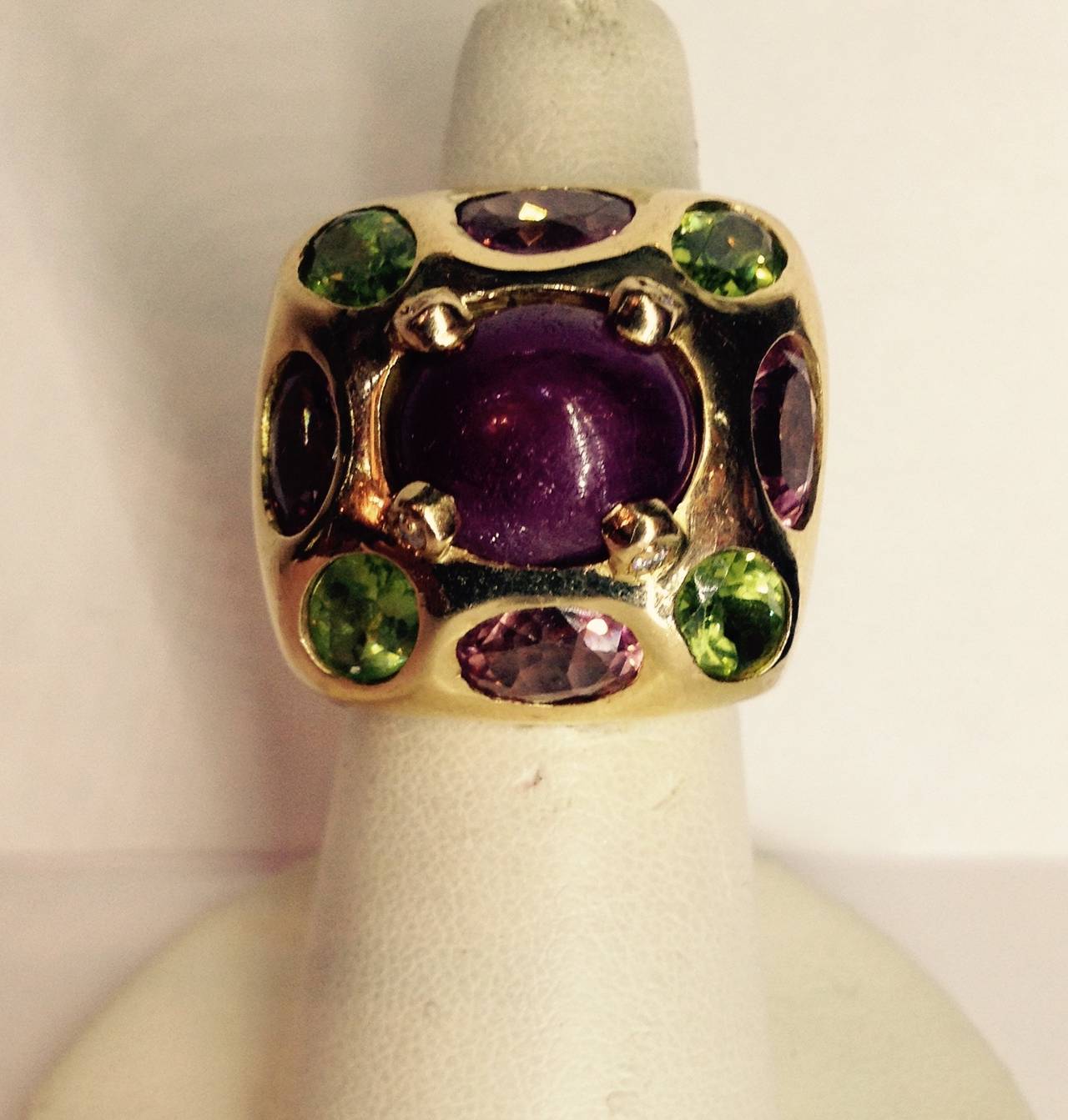 18Kt Yellow Gold Large Cocktail Ring, Designed With A 5 Ct Cabochon Ruby In The Center, Further Embellished With Alternating Faceted Pink Tourmaline And  Peridot Stones, Prongs Set With Diamonds In The Mounting, American Made, Circa 1960's.
